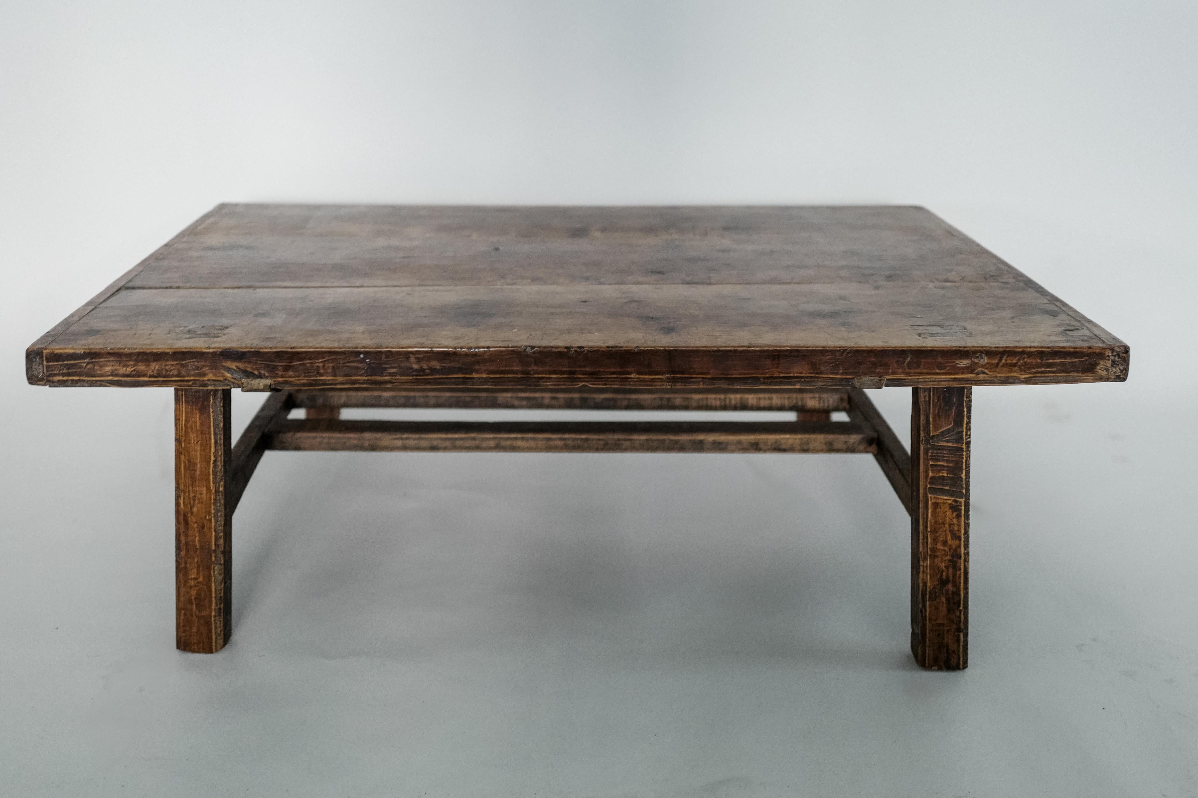 This antique 19th-century Chinese walnut coffee table exudes timeless character with its rich, dark patina and hand-carved details that highlight the natural grain and craftsmanship of the era. Crafted with a simple, sturdy design, this rectangular