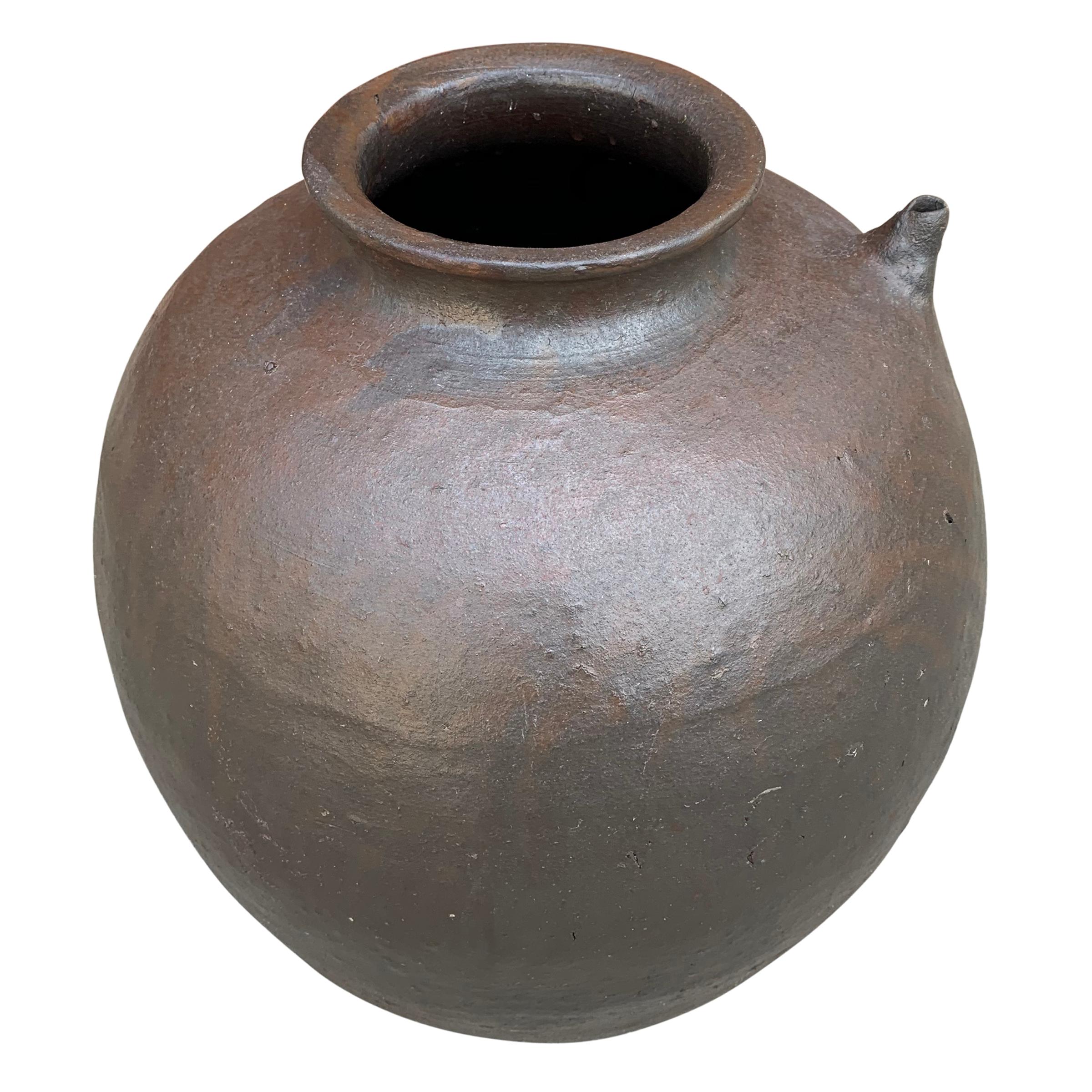 A beautiful 19th century Chinese ceramic wine jar of graceful ovoid form, with a narrow neck, a small spout, and a wonderful charcoal and rust colored glaze.