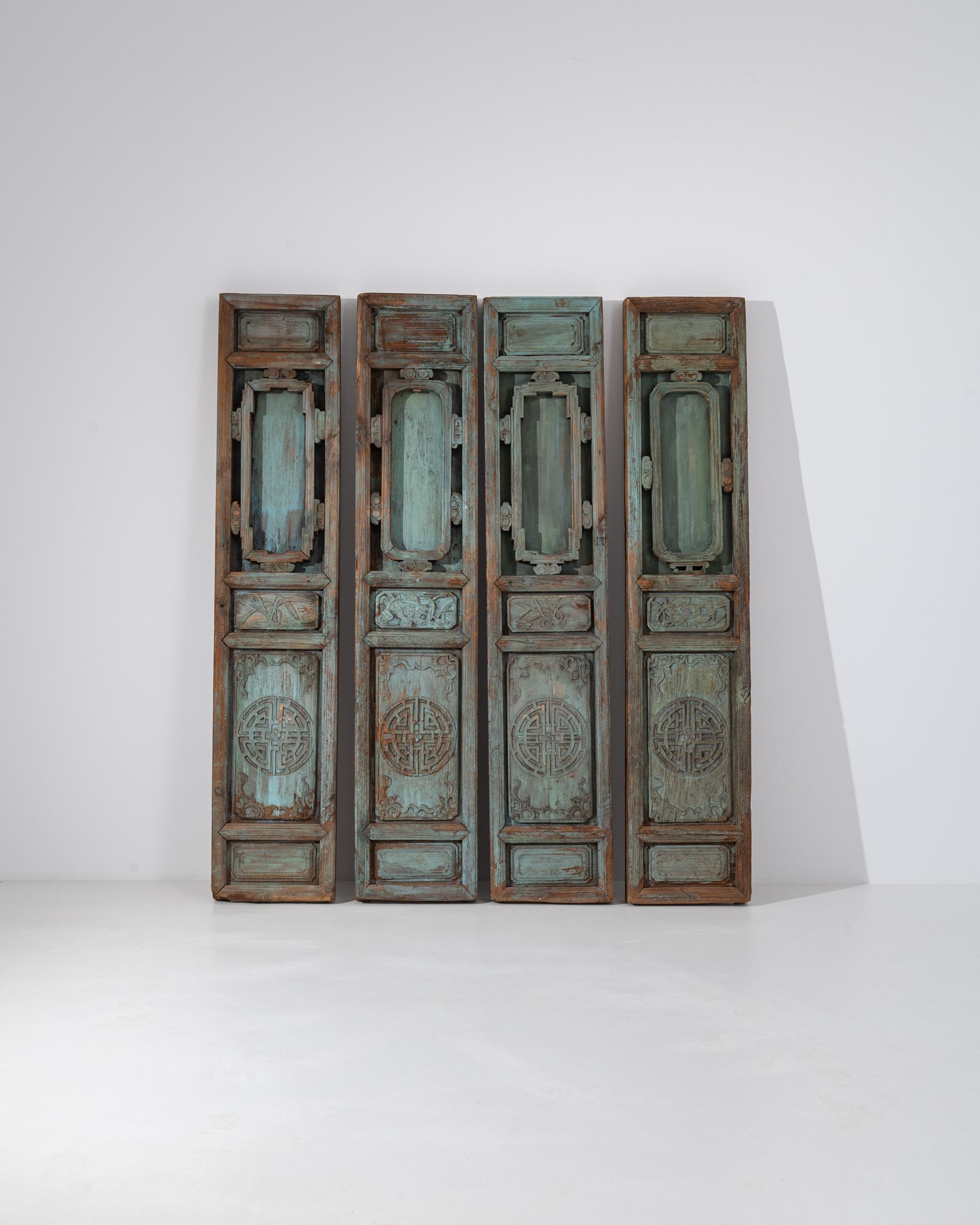 A set of 19th century decorative wooden doors from China. These tall sculptural panels rest with a pensive, contemplative aura. Beautifully carved floral motifs are framed above a mandala pattern, which is complete with a lotus flower in its center.