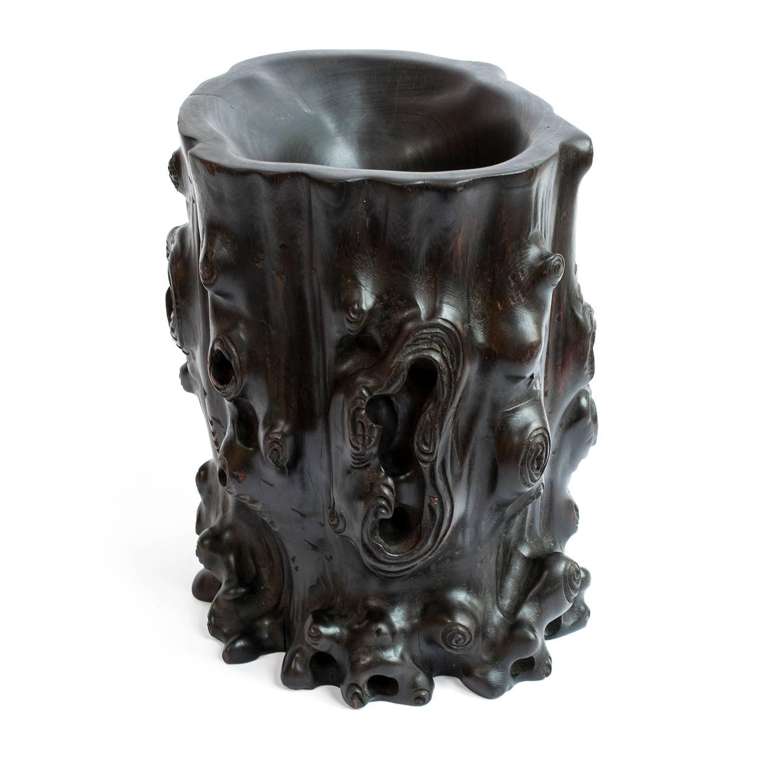 Ce pot à pinceaux sculpté à la main:: bitong en chinois:: contenait probablement des pinceaux de calligraphie sur un bureau dans le studio d'un érudit. Il est sculpté en Zitan:: un bois dur chinois sombre:: précieux et aujourd'hui disparu. Conçue
