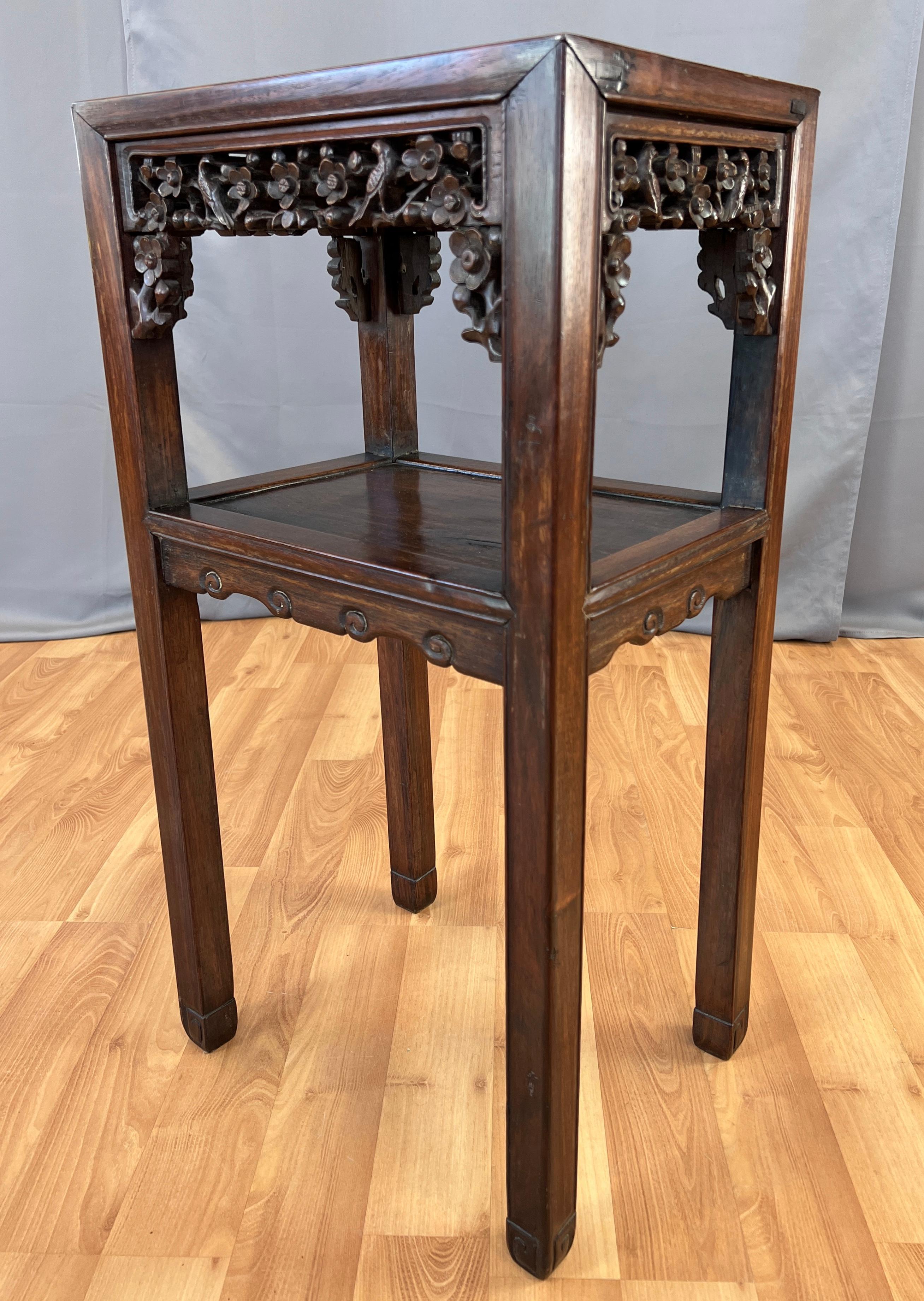 Offered here is a wonderful 19th century Chinese Zitan wood tall end table, with intricate hand carved relief on it's apron, with a shelf that has a simple carved apron.