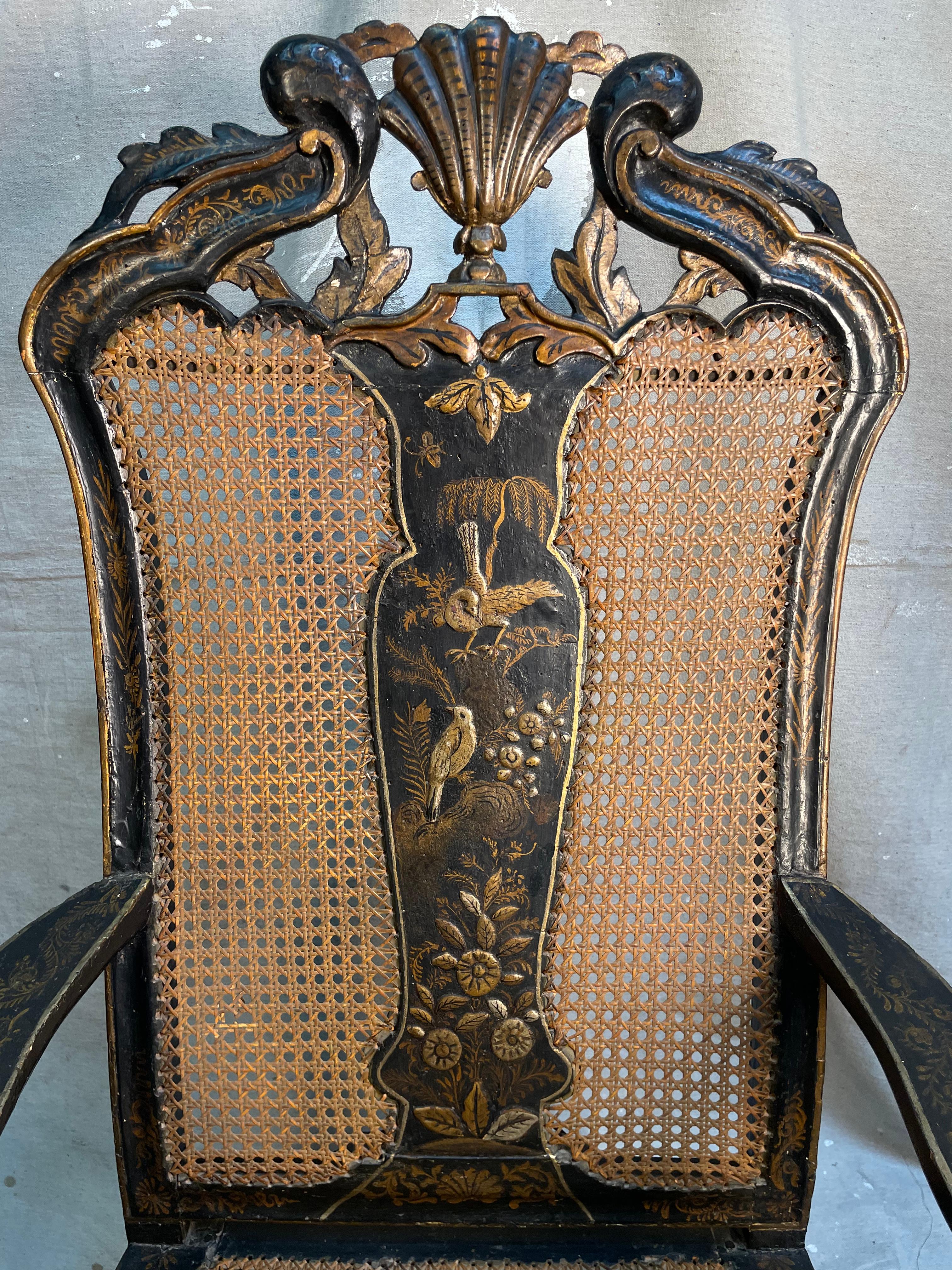 This 19th century English Chinoiserie Armchair is in the Queen Ann style. It is hand painted, hand carved, and caned. It is decorated in beautiful scenes of foliage, birds, and shells in shimmering gold leaf; giving us a dancing energy of a tropical