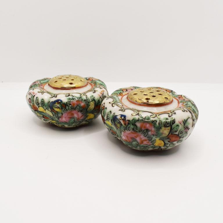 A beautiful pair of 19th-century chinoiserie salt and pepper shakers. Created from ceramic in a squash shape, this set of shakers features a pink famille rose design on their bodies, and gold painted detail on the tops. A lovely accent to your next