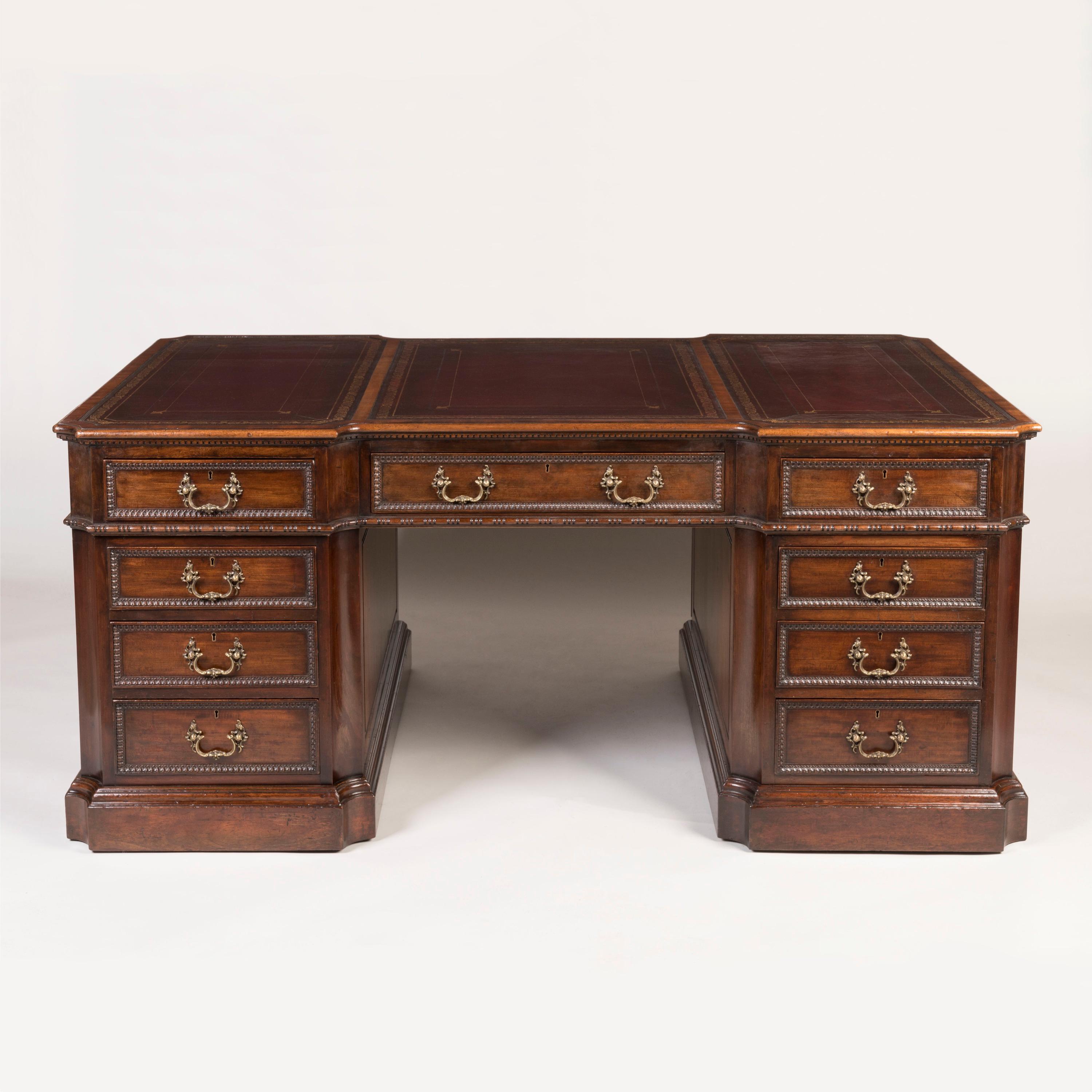 A Handsome Partner's Desk
After the Chippendale Design

Made from fine mahogany, with finely cast brass hardware, the desk supported on rolling casters hidden under the thumbnail moulded plinth, each pedestal with incurved corners housing a bank