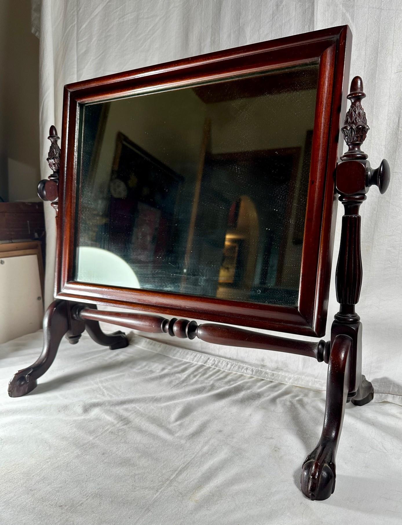 Specchio da comò con piedini in mogano intagliato in stile Chippendale del XIX secolo. 

L'affascinante specchio da tavolo, da barba o da comò inglese è in mogano intagliato e progettato in stile Chippendale.  Lo specchio poggia su quattro piedi a