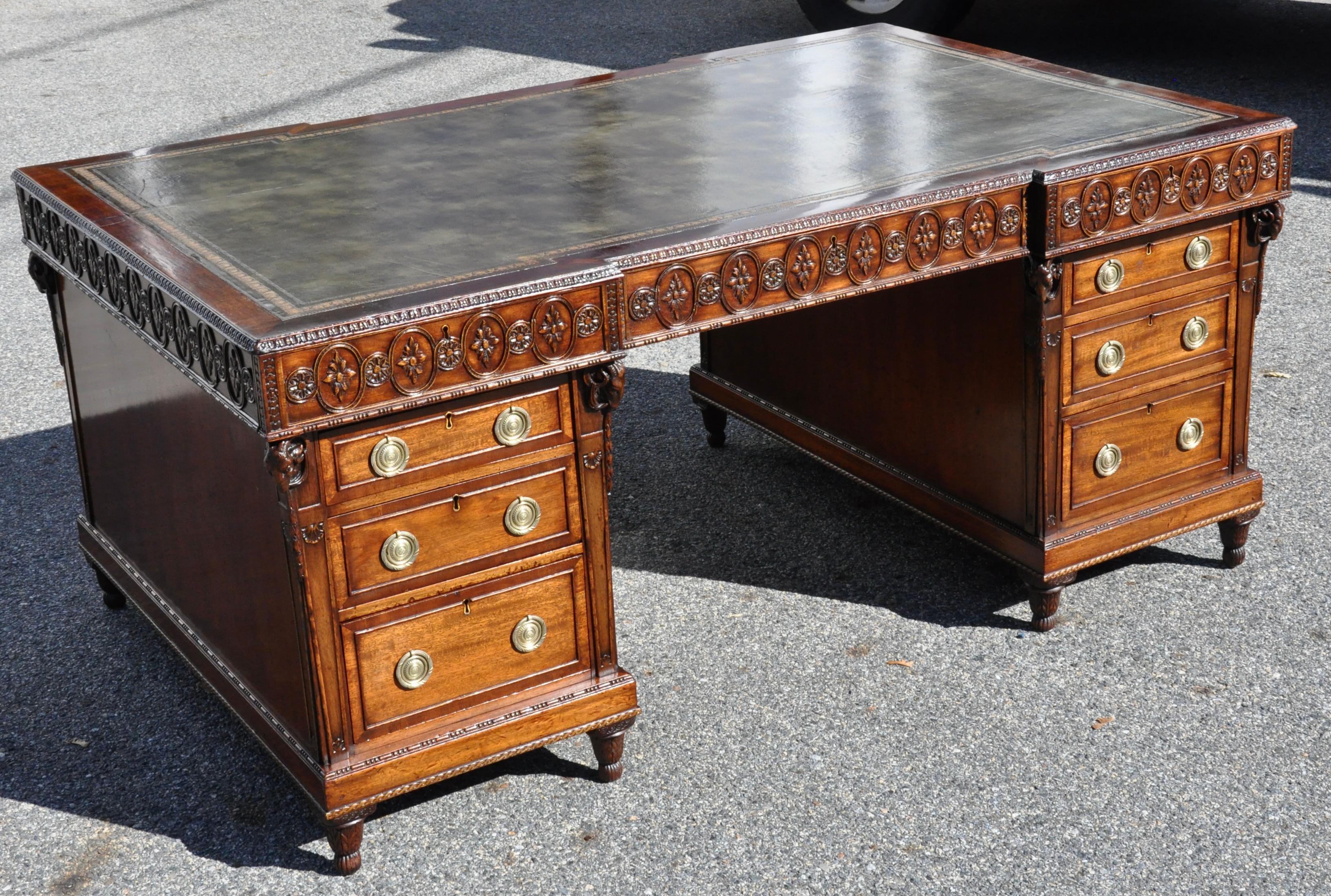 Fine 19th century Mahogany Chippendale style partners desk. Carved throughout. Adams inspired from The Directory. Green tooled leather top. Drop with Frieze drawers on both sides and base cabinets with drawers on one side and functional cabinet door