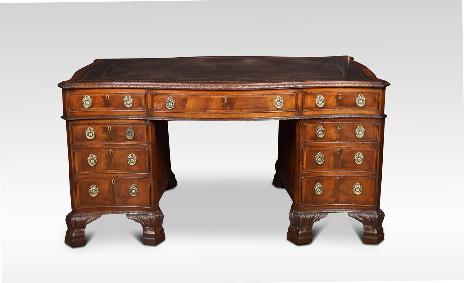 A 19th century Chippendale style mahogany desk. The large serpentine top with inset green tooled leather writing surface. Above three freeze draws. To the twin pedestals with panelled sides, the pedestals fitted with three graduated draws and brass