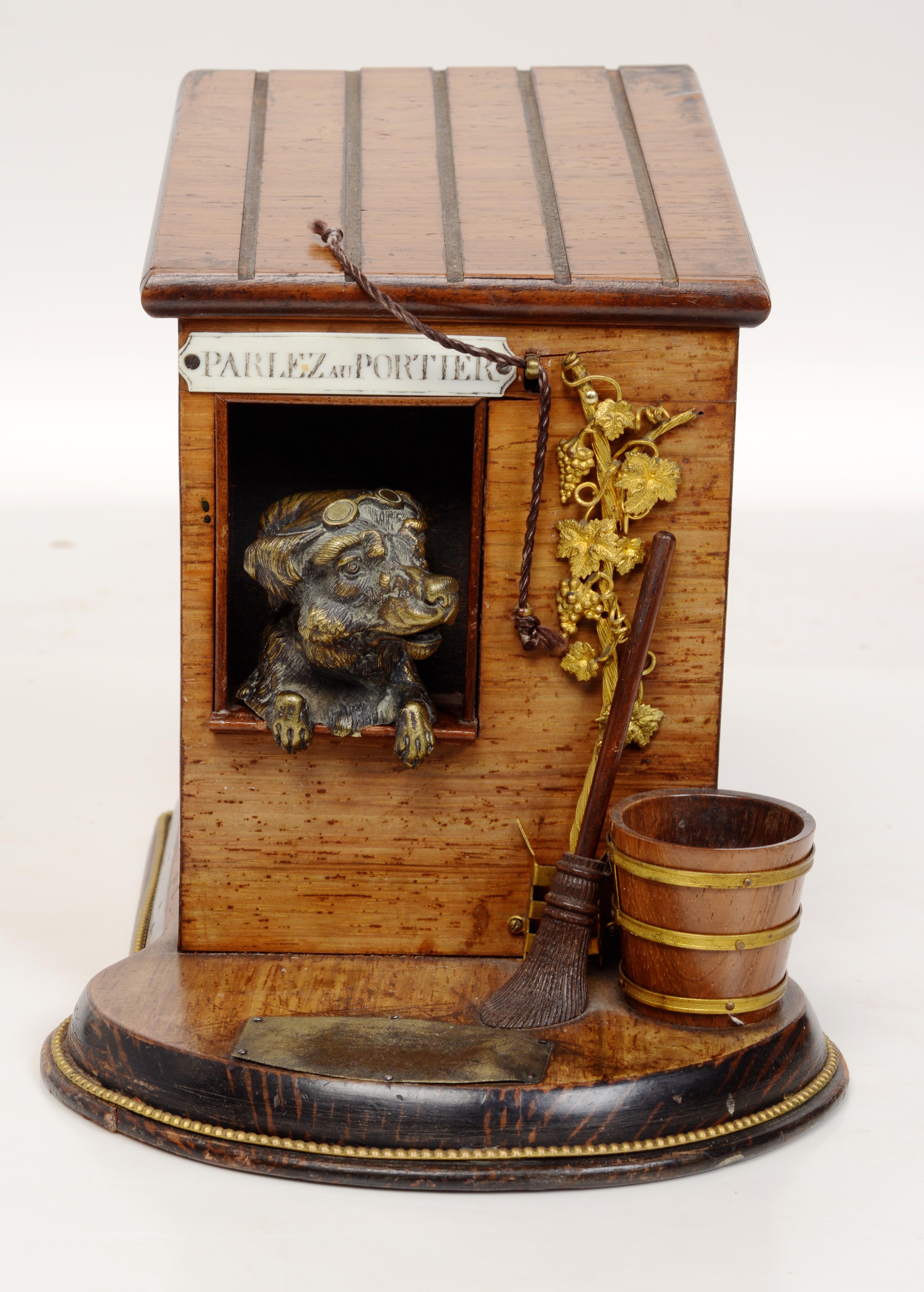 19th Century Cigar Box With a Terrier in A Dog House, French, c1890. Exceptionally rare and highly sought after, this whimsical piece features an adorable cast brass terrier with a hat and glasses guarding his master's cigars. The walnut case with