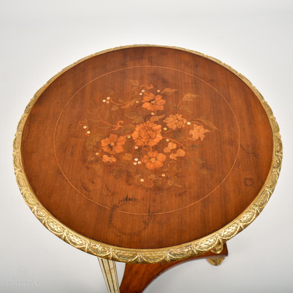 Late 19th century satinwood Empire influenced circular occasional table. Inlaid with flowers and fruitwoods, olivewoods and mother-of-pearl. The brass Roman style columns would have been gilded as would the brass garland border to the top, the
