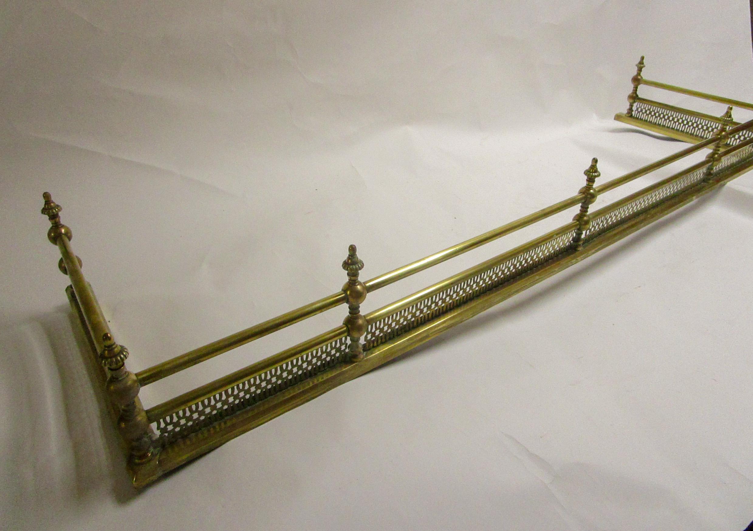 Classic Regency period brass fender having a reticulated frame work. A handsome solid piece in a large size. Inside measurements 59 inches wide x 15.75 deep. Over-all measurements above.