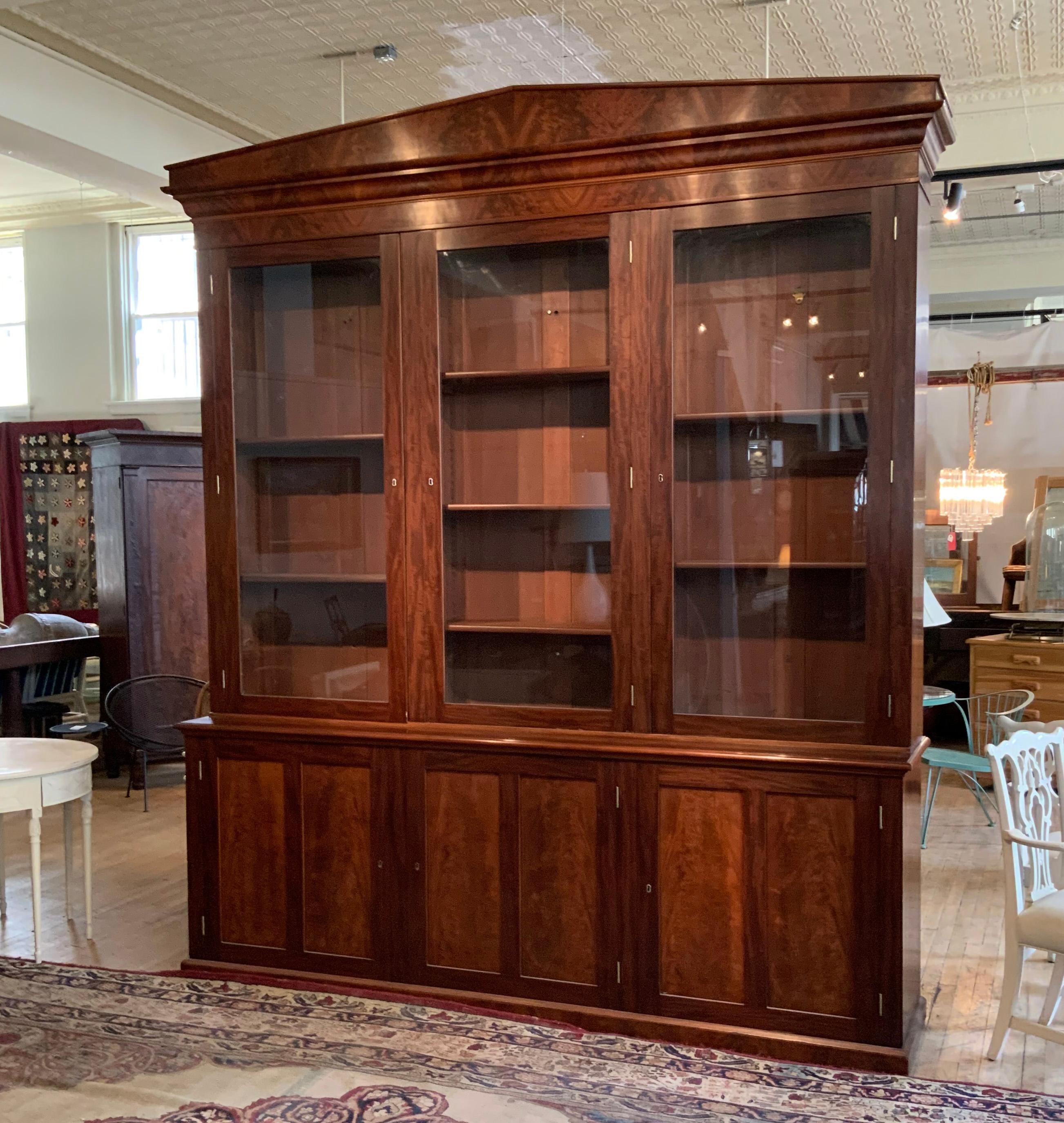 A very handsome and impressive large mahogany bookcase cabinet from a Harvard library. This beautiful cabinet has three glass doors above with many adjustable shelves, and three mahogany doors below also concealing adjustable interior shelves.