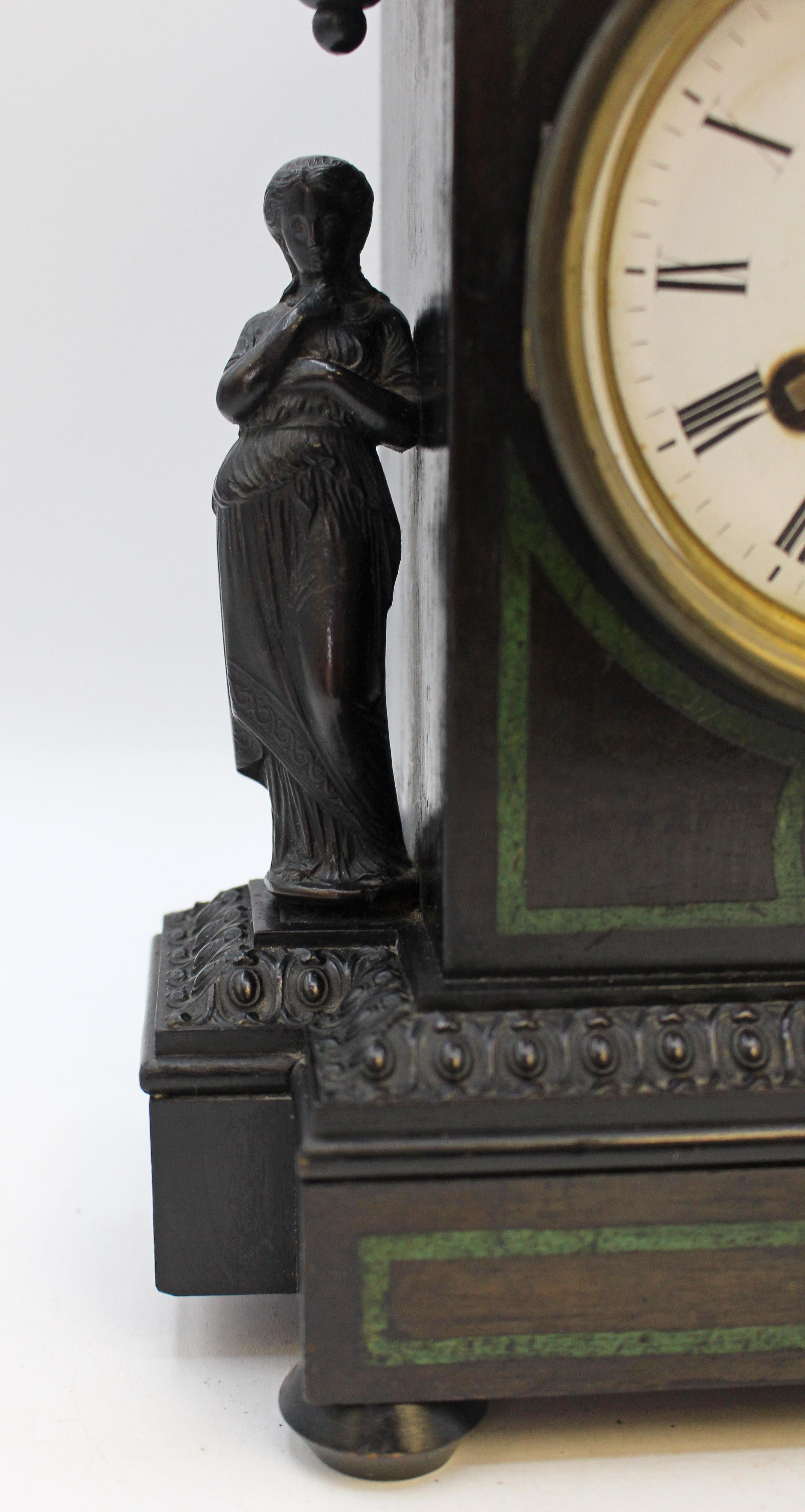 19th century Classical taste table clock, Anglo-European. An attractive & unusual ebonizid wood & faux malachite table clock raised on bun feet. Flanked by Classically dressed women. Egg & dart border. Runs with some effort, may need adjustment.