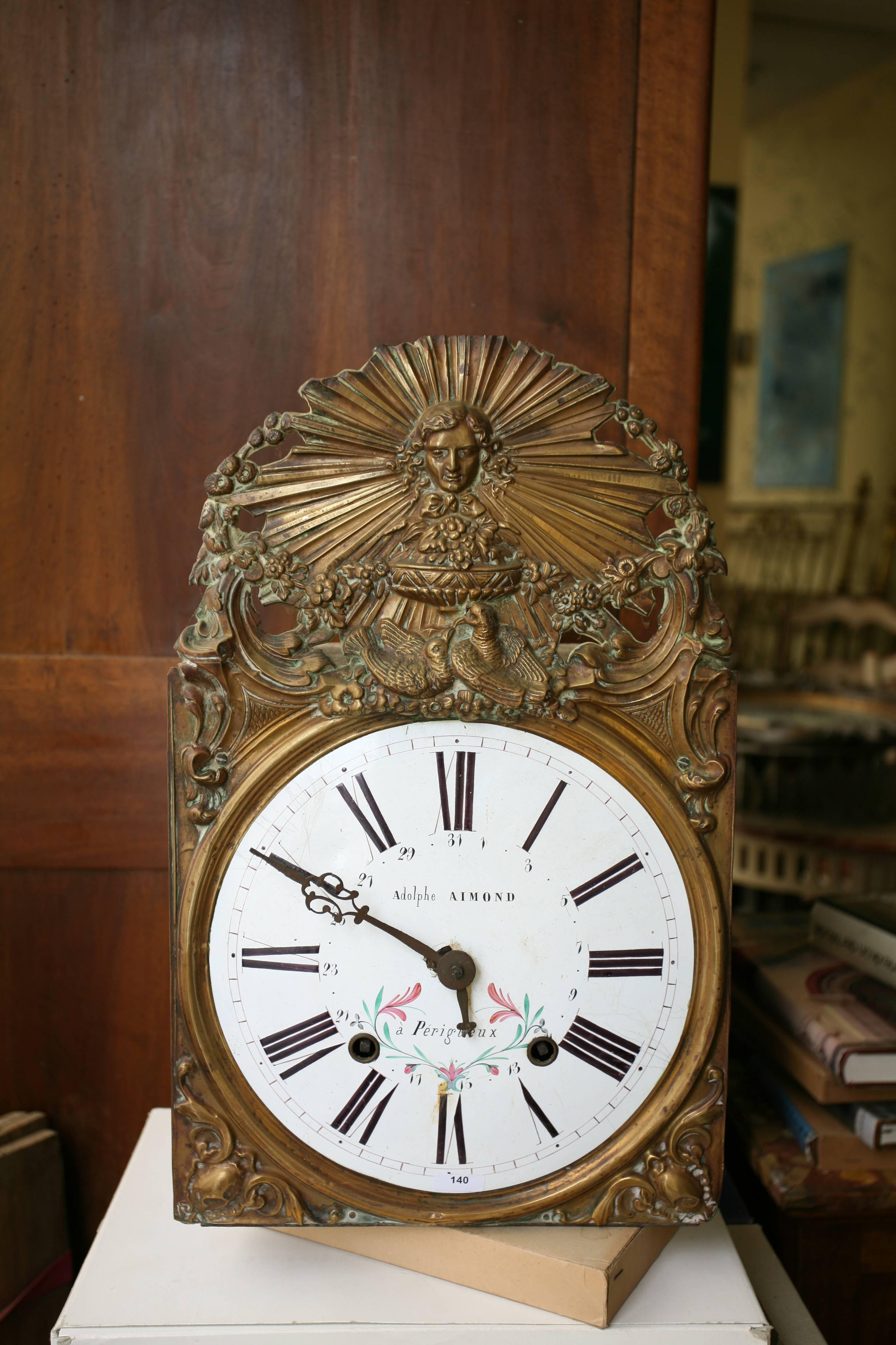 Movement and comtoise clock head with beautiful brass decoration and enamelled dial with Roman numerals by Adolphe Almond in Périgueux. (Enamel cracks and accident with a needle).
France, circa 1890.