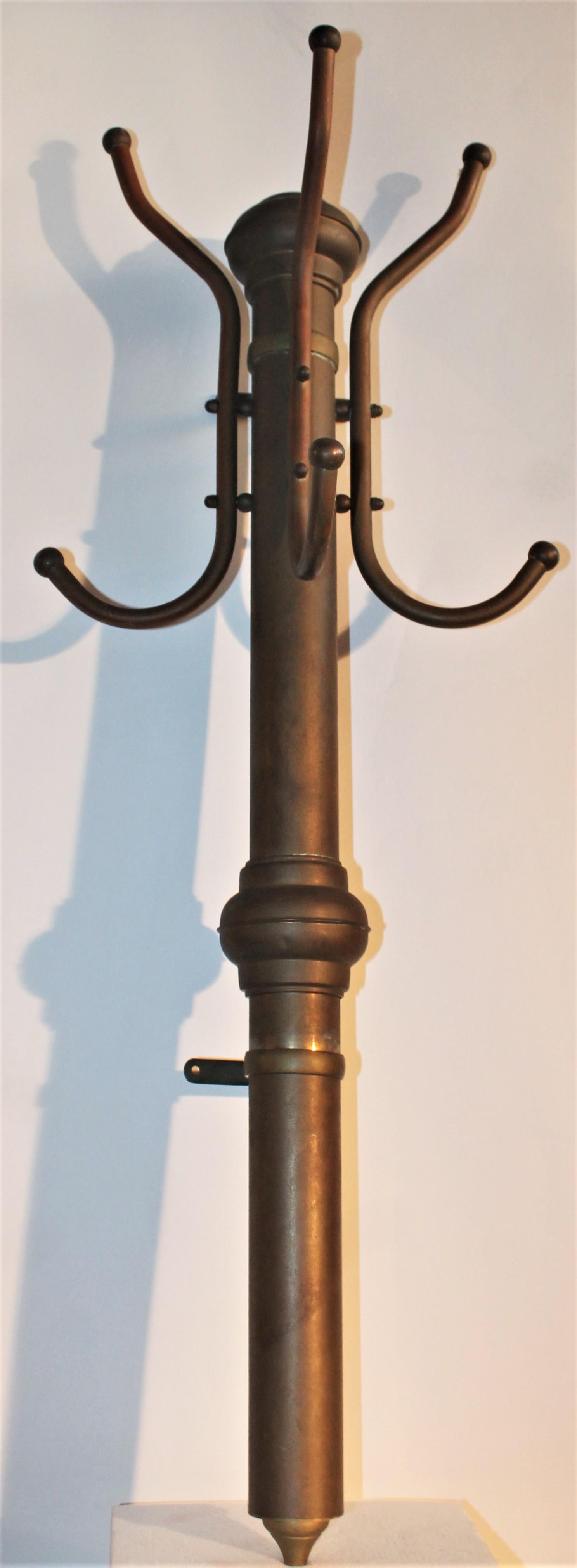 This rustic and nicely patina brass hat and coat rack is in great sturdy condition. The look is like a train station rack or from a old saloon.