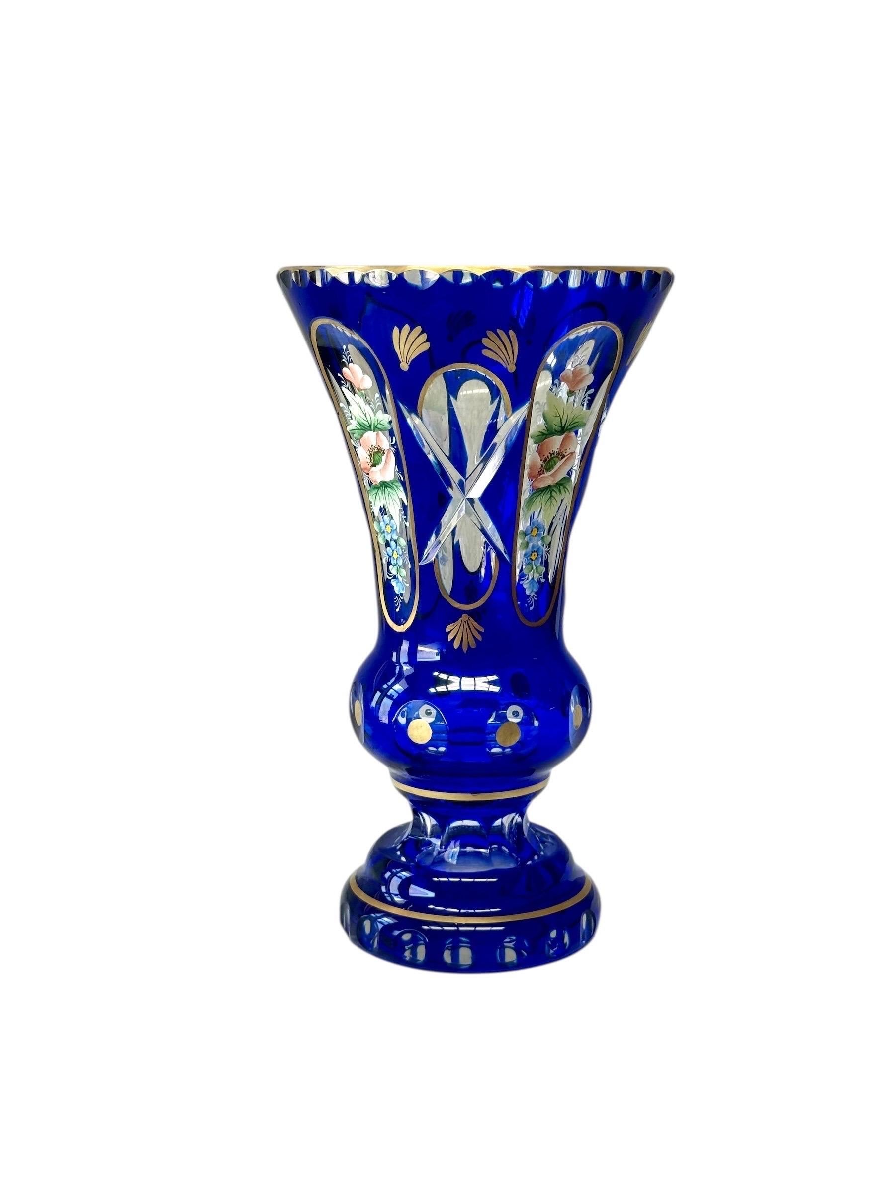 Magnifique vase en cristal bleu du XIXe siècle, finement taillé à la main et richement décoré d'émail et d'or. Le cristal bleu cobalt profond a été recouvert et taillé de manière experte pour révéler des panneaux de cristal clair, créant un