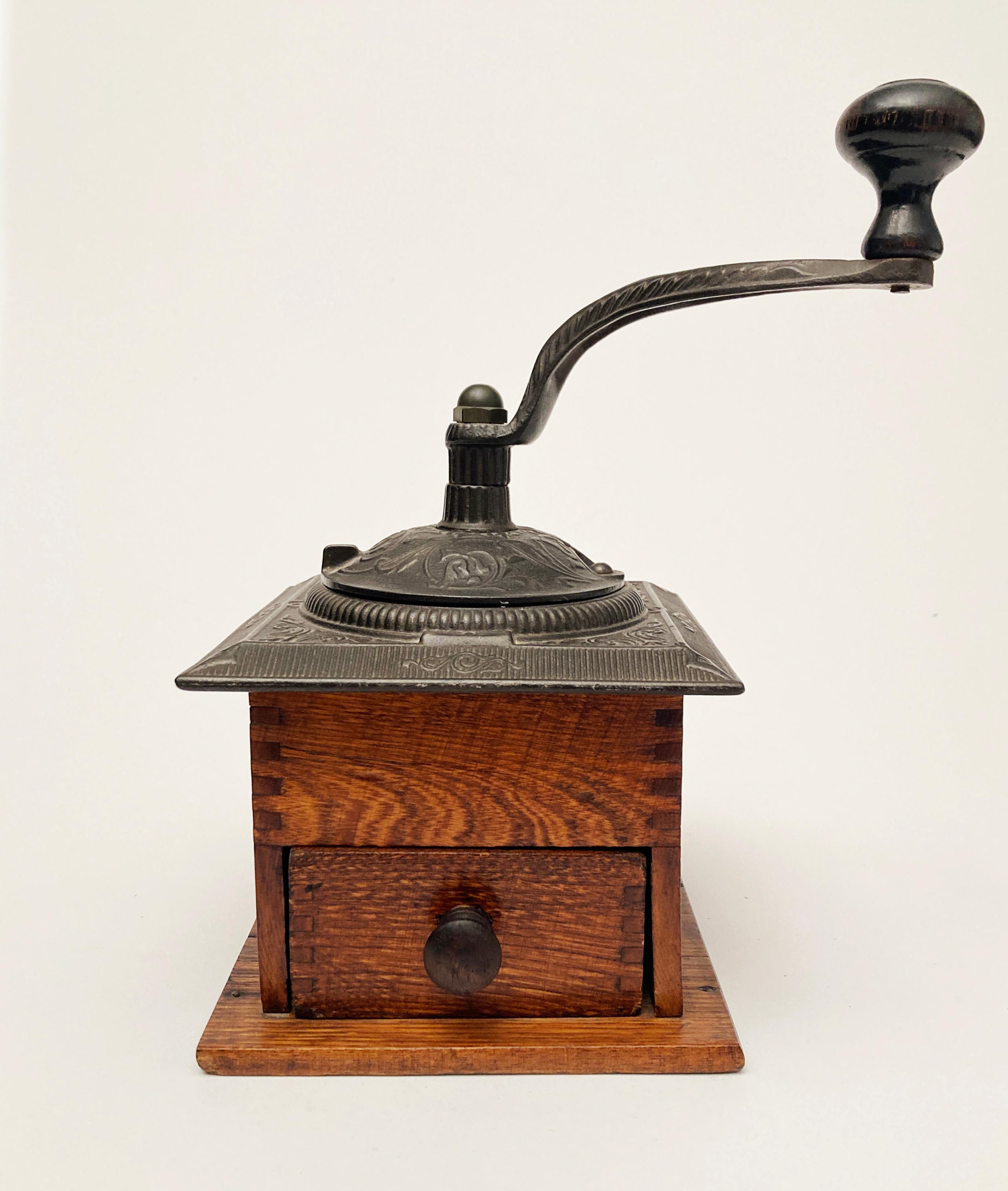 This well-preserved piece of American Coffee history is a site to behold. With it's ornately decorated  iron grinder sitting atop an oak  base joined with beautiful small dovetail joints and finished in a wonderful rich pecan, this piece is a