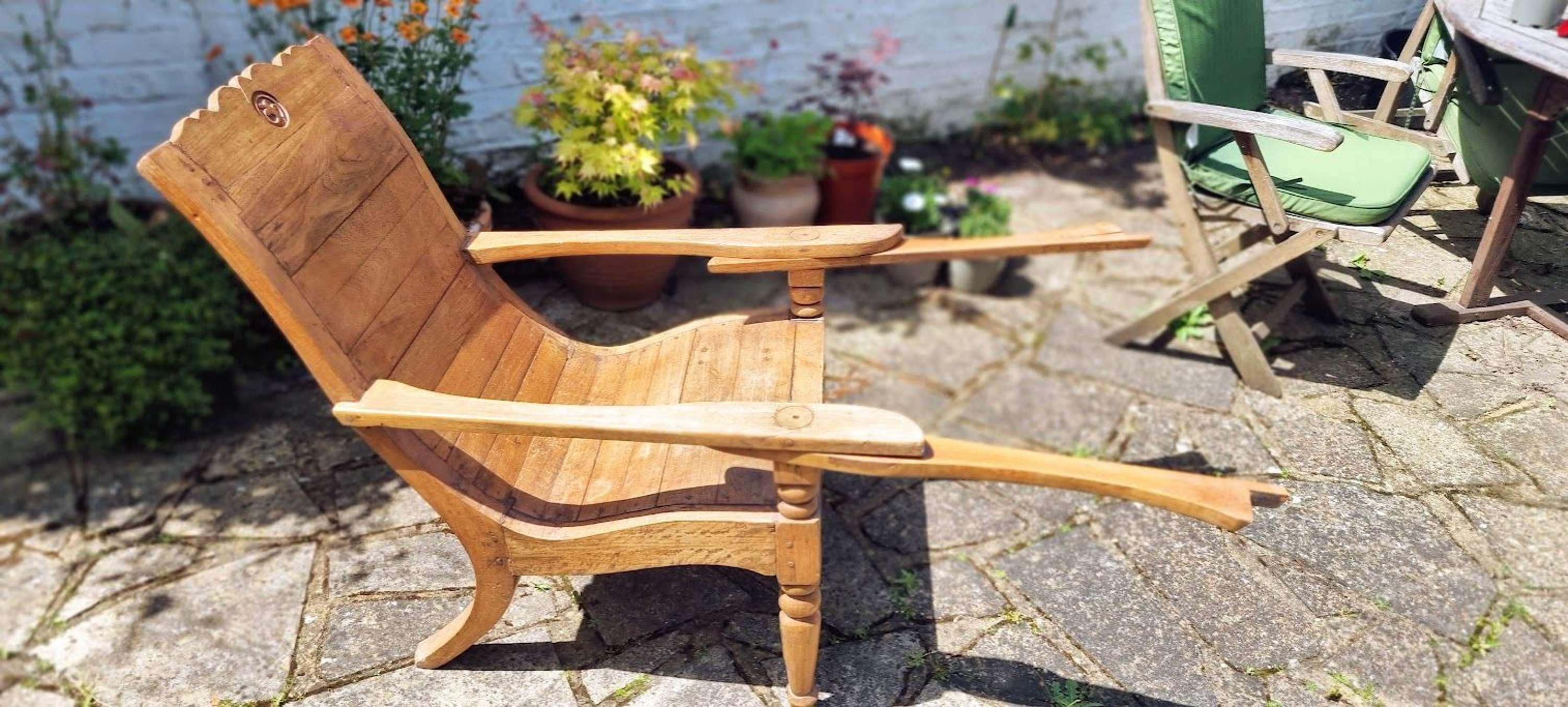 A striking 19th century colonial anglo indian plantation chair made from pegged teak with fold out leg supports.

Wonderful ergonomic form on beautifully turned and hand carved legs 

with original hand carved designers motif.