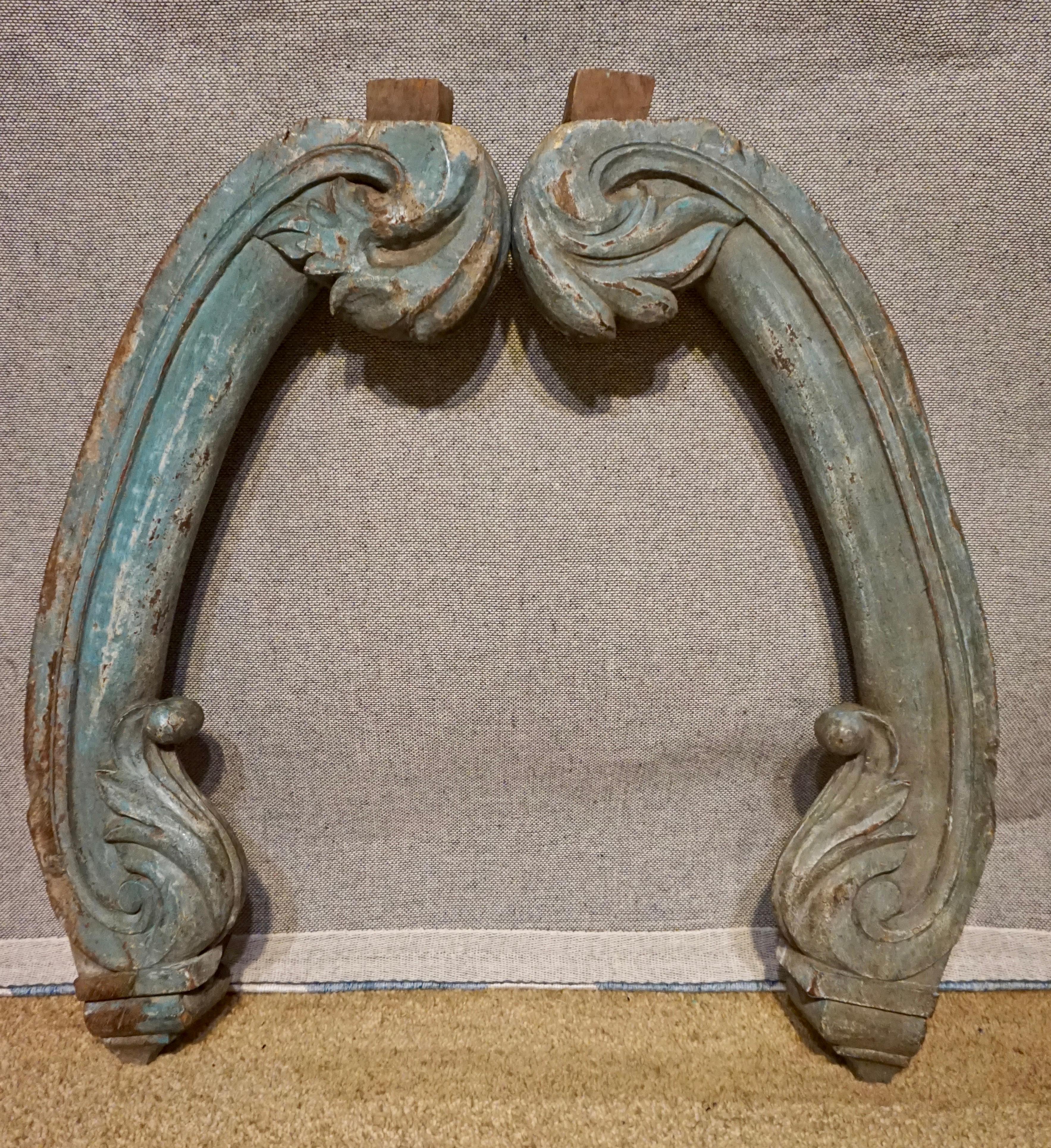 Large hand carved corbels made from solid teak with original paint and rustic details. Originally used under balcony. These are heavy duty and are shaped like scrolling elephant trunks. Original broad nail fixture can be seen, circa 1890s.

    