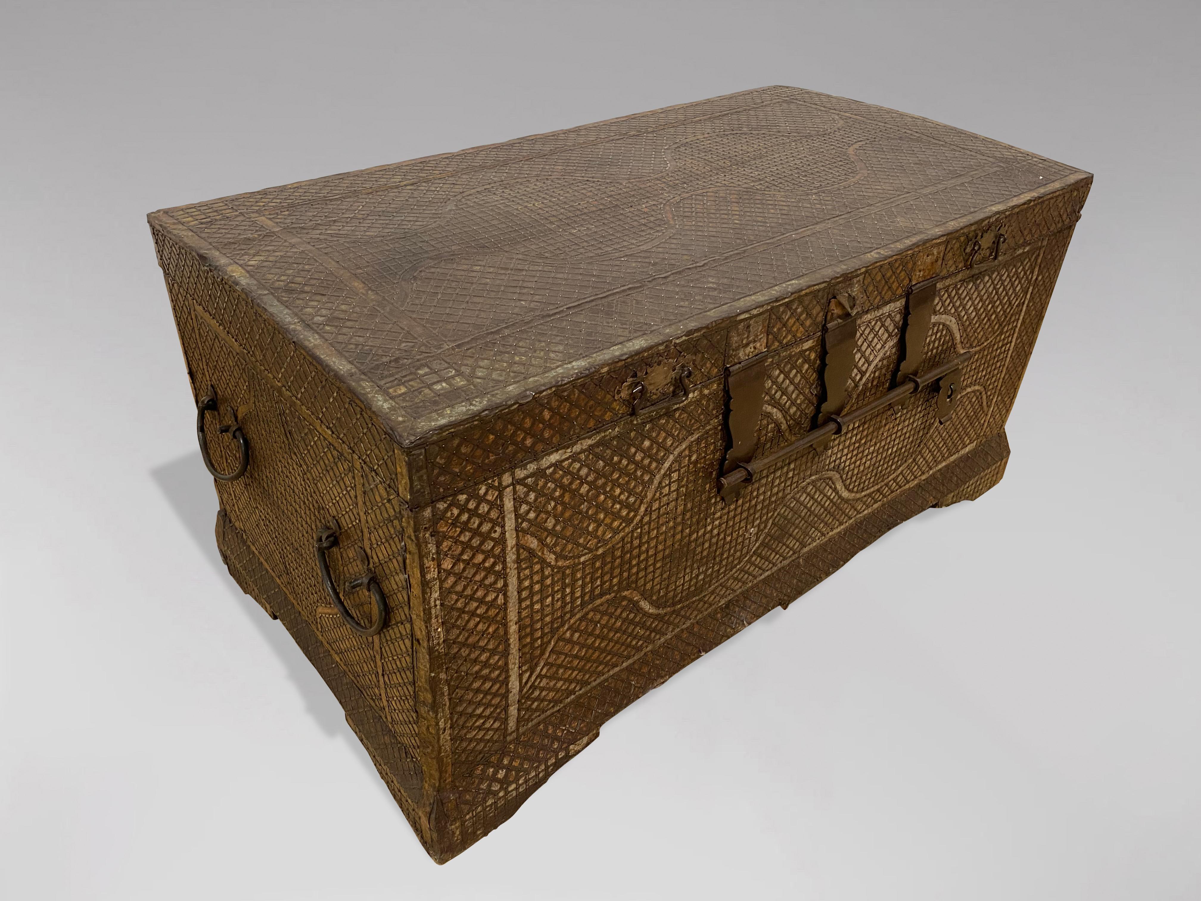 A late 19th century handcrafted colonial travelling chest or trunk with embossed metal overlay and mounts. The trunk comprises solid carved teak wood and features a hinged lid. The interior is in good clean condition. The chest is adorned with