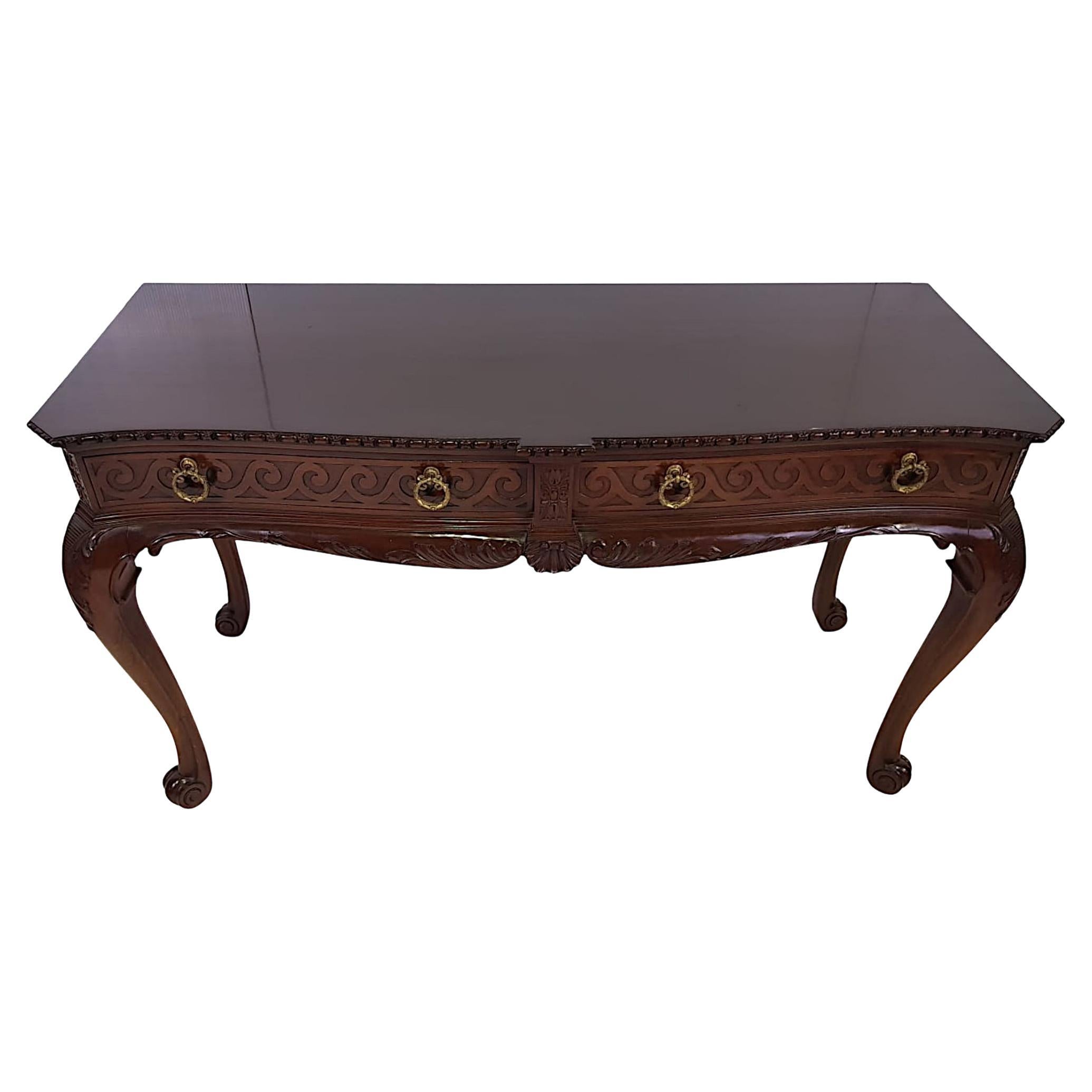 A lovely 19th Century Victorian mahogany console or hall table, the shaped moulded top of rectangular form with canted corners, lozenge and dart carving raised over frieze with two long drawers, decorative brass ring pulls and carved flower head