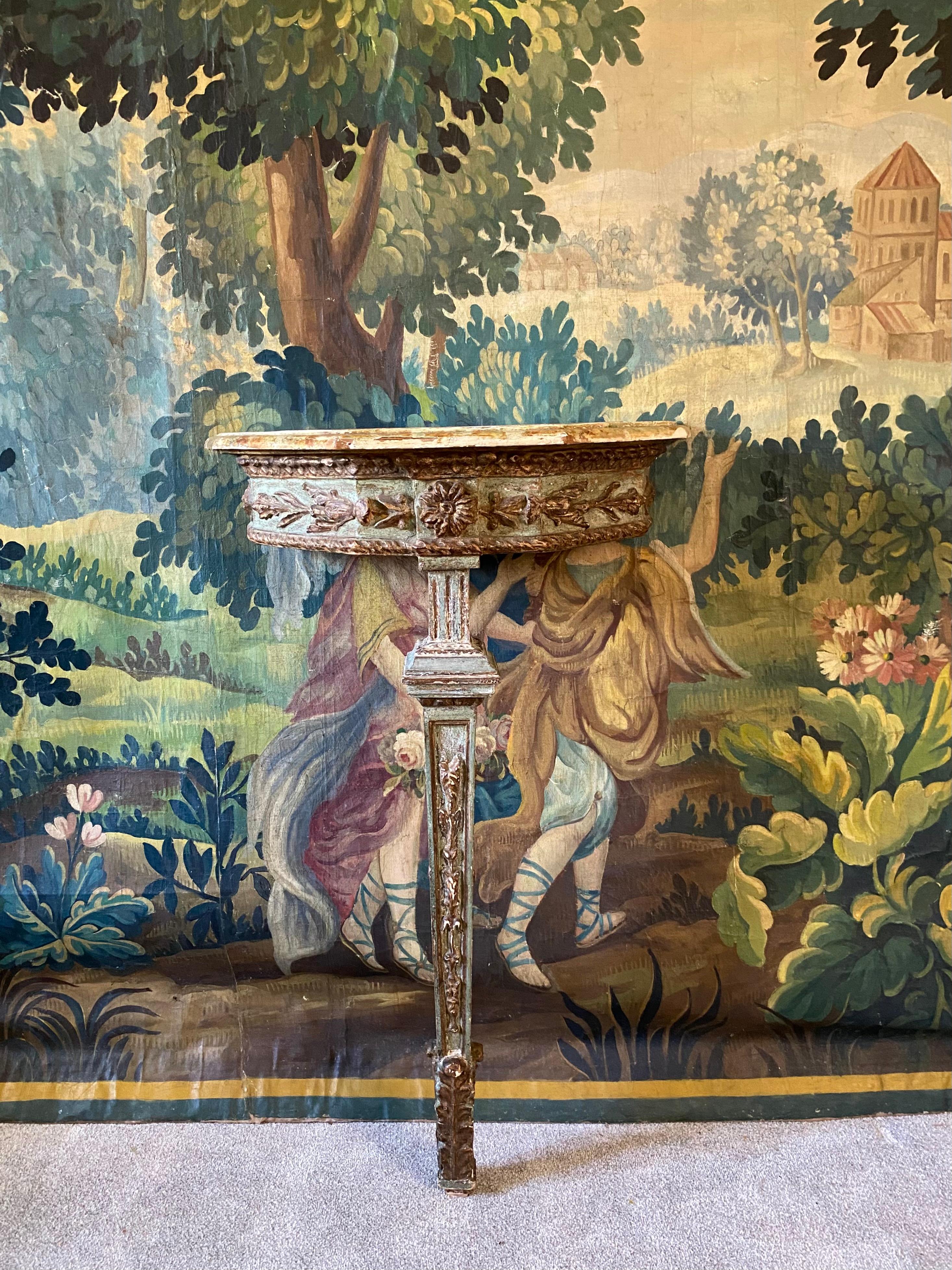 Une petite table console italienne du 19ème siècle très charmante avec des sculptures décoratives à la main dans une douce peinture d'origine vert moyen avec des reflets dorés délavés et finie avec un dessus faux marbré peint à la main dans un bel