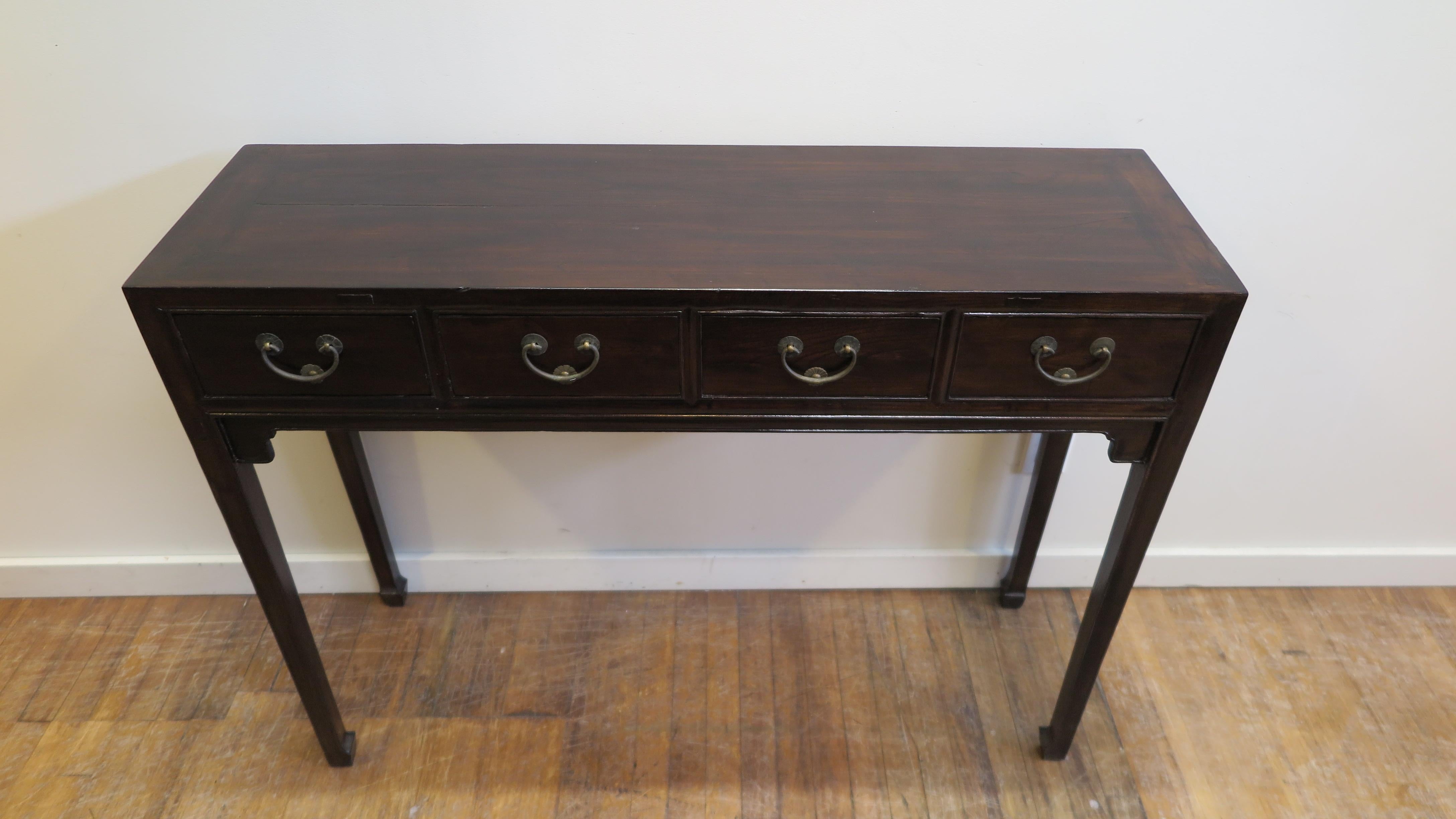 19th century Chinese console table. Four drawer thin console table elegant refined lines with swing handles and bumpers. Detailed apron with horse hoof feet. Good condition commensurate with age and use. Please see pictures. Having dings to the