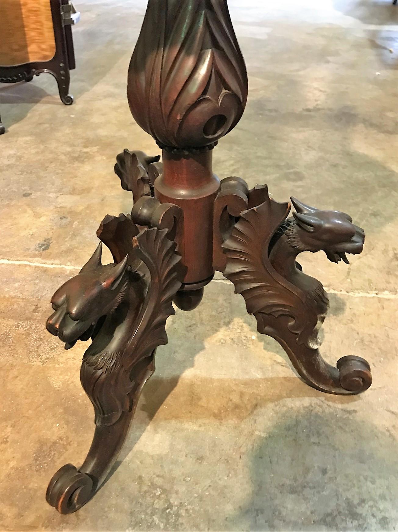 Rare 19th century continental Black Forest shaving stand expertly carved with griffins, flowers, vines, and berries. Leaf-spray crest, beveled oval mirror with bead trim, and tripod base. Accented with two brass candleholders,

circa 1880.