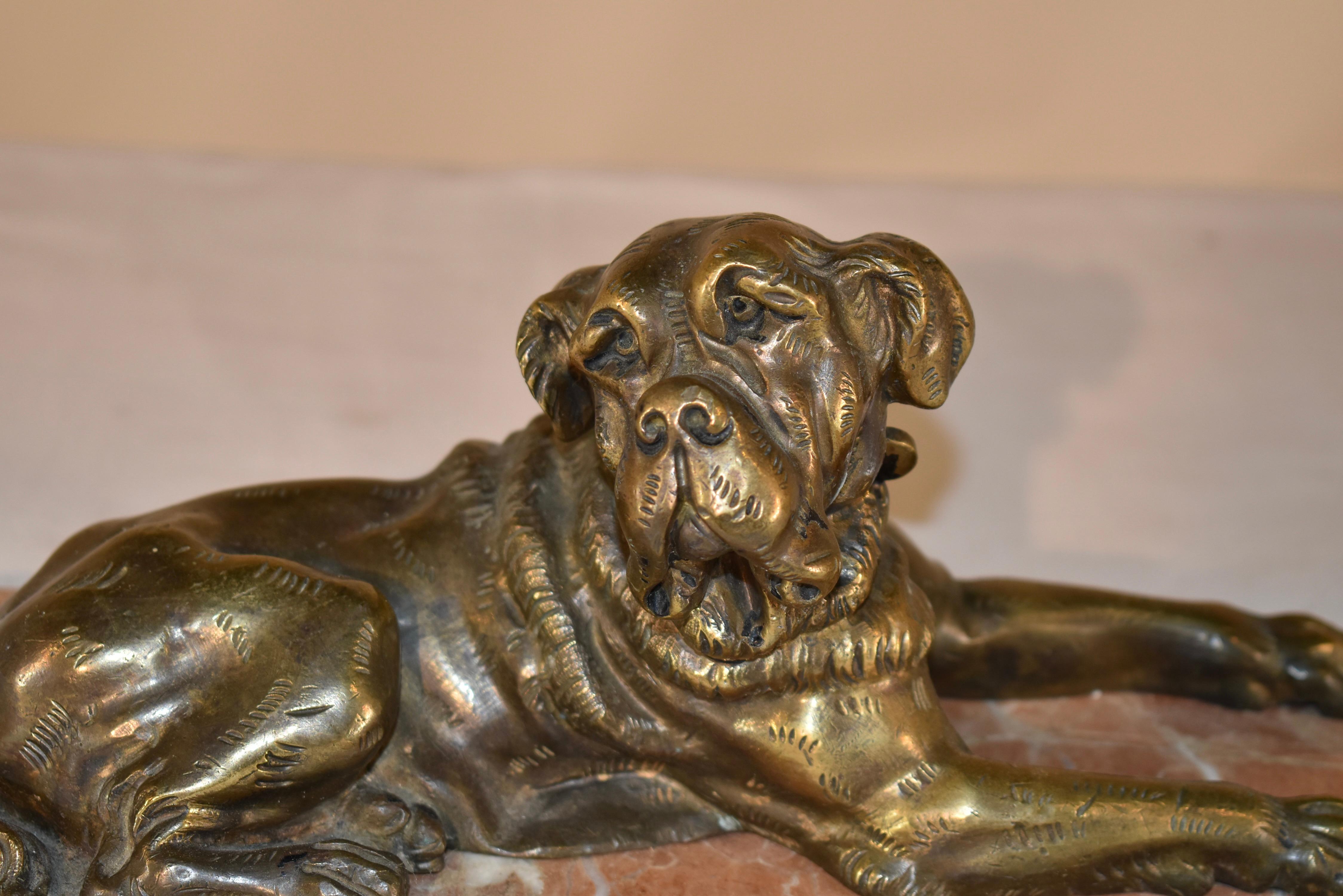 A 19th century wonderfully hand cast bronze of a recumbent mastiff hound, the dog is modeled lying at rest, with a collar around his neck.  He is supported on a wonderfully colored marble base.