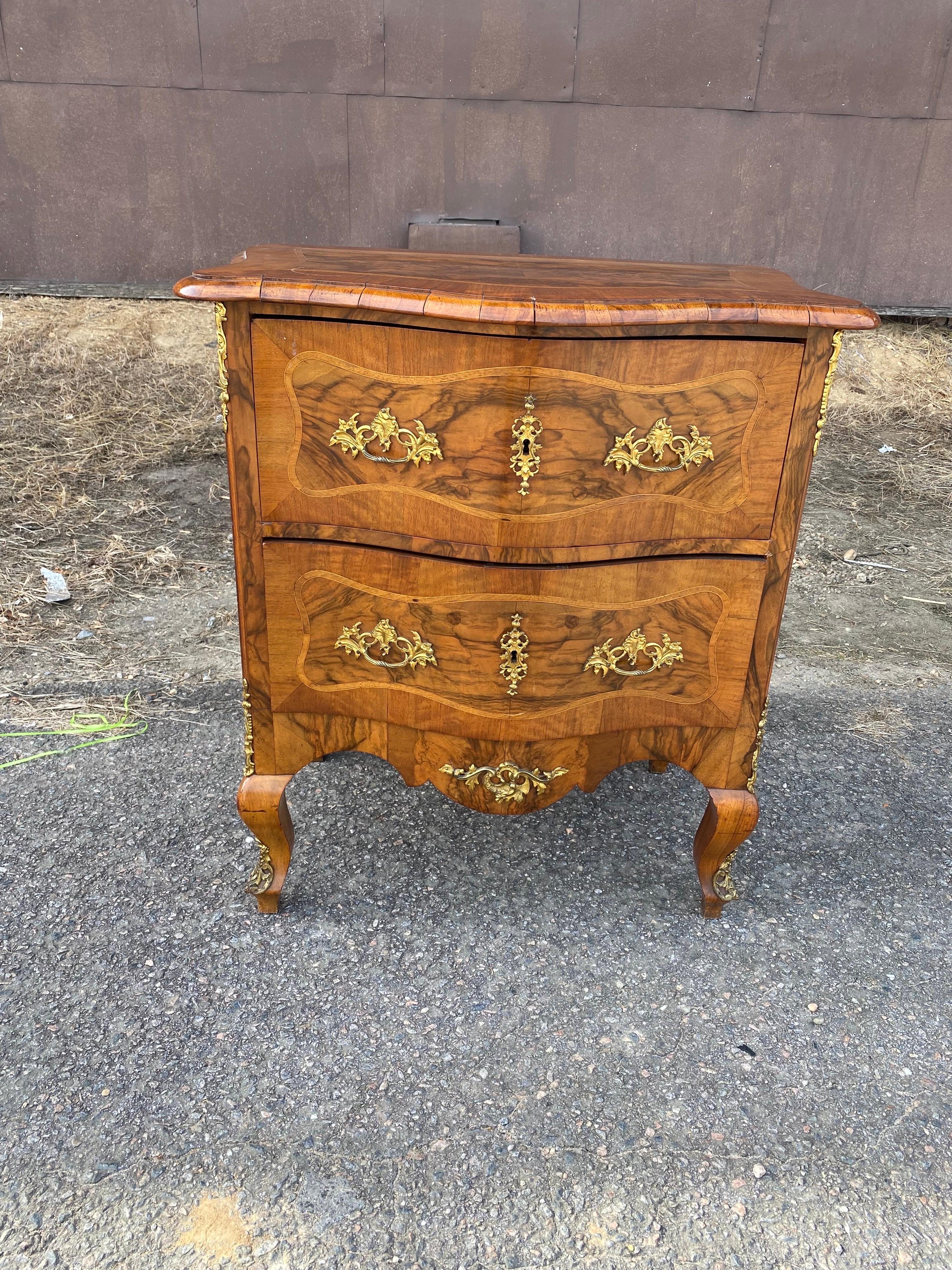 Great little 2 drawer 19th century continental inlaid bedside chest. At 31.5” high, it would be perfect as a side table or bedside chest.