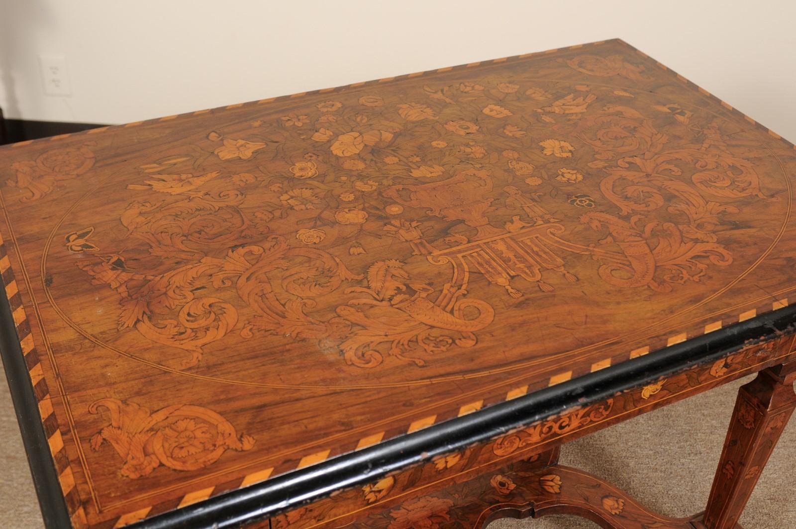 A 19th century continental rectangular form center table featuring marquetry inlay with foliage, flowers, birds and figures. The ebonized boarder top above single large drawer in frieze and stretcher below joined by square tapering legs ending in