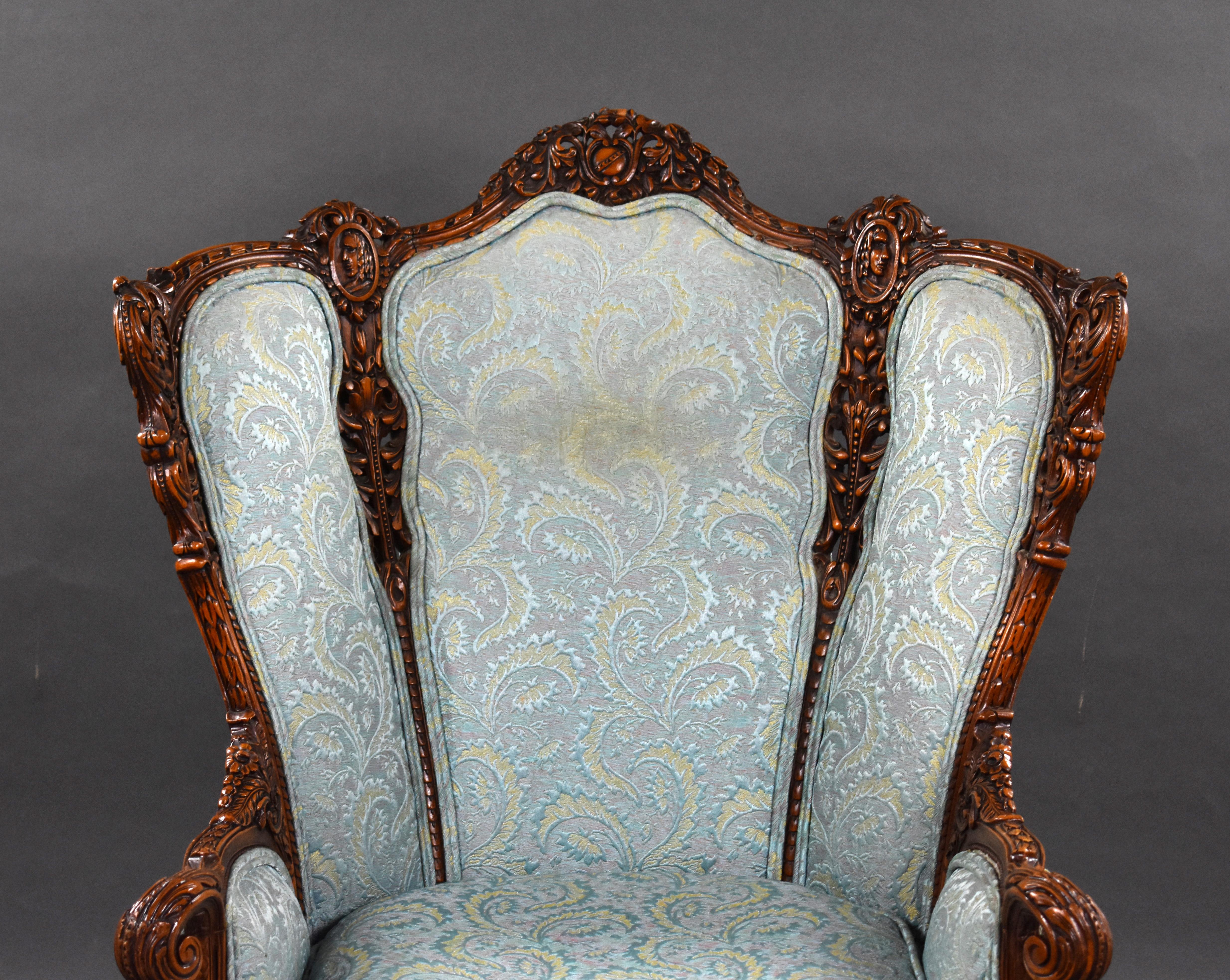 A good quality 19th century walnut armchair of bowed form with ornate ribbon, mask and scroll carved frame and cushion upholstery with out scrolled arms and cabriole legs. 

Measures: Width: 90cm depth: 86cm height: 120cm.