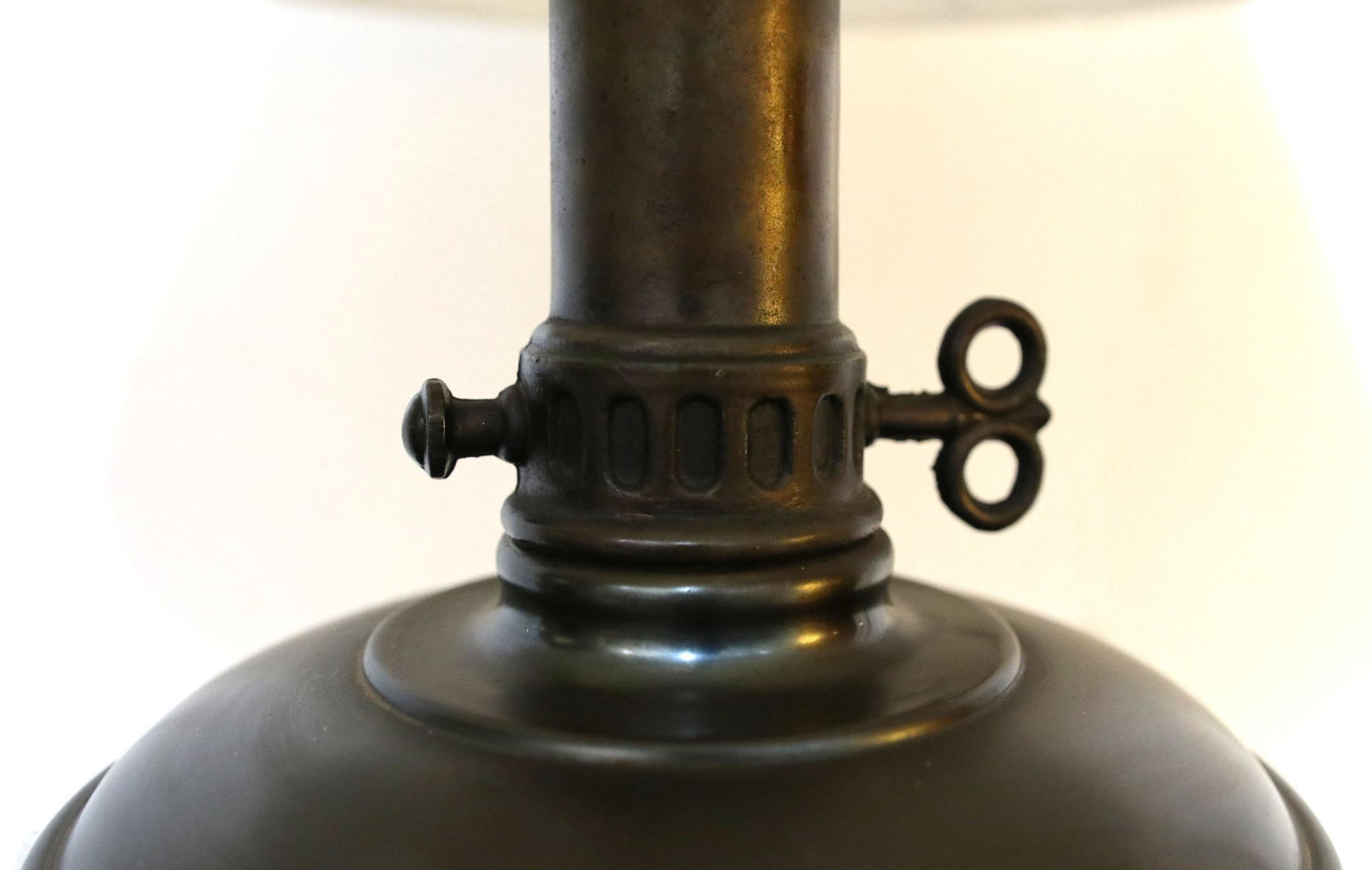 The design and details of this converted lamp make it a standout. It is a neoclassical style brass, bronze and porcelain lamp that is elegant and traditional.  The top part of the lamp is brass while the base is likely bronze. This appears to have