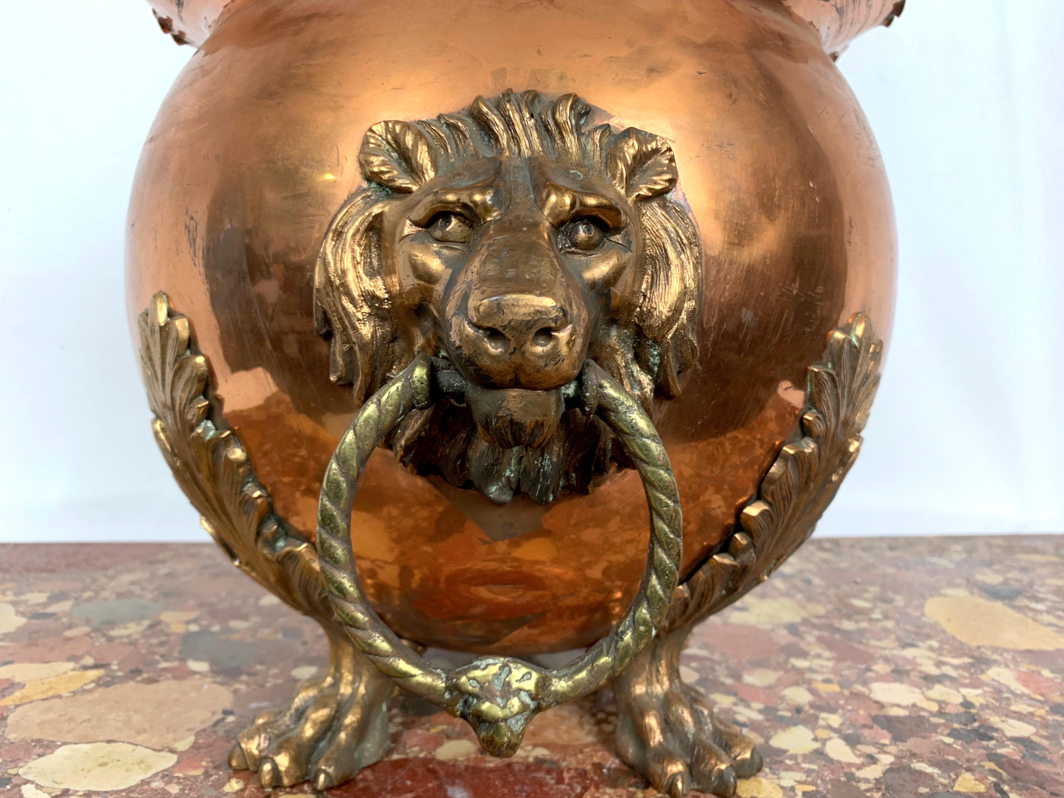 This is a 19th century Victorian antique copper and brass lion mask ring handled coal or log bucket, tripod lion paw feet. Lovely condition and quality, circa 1850. 
 