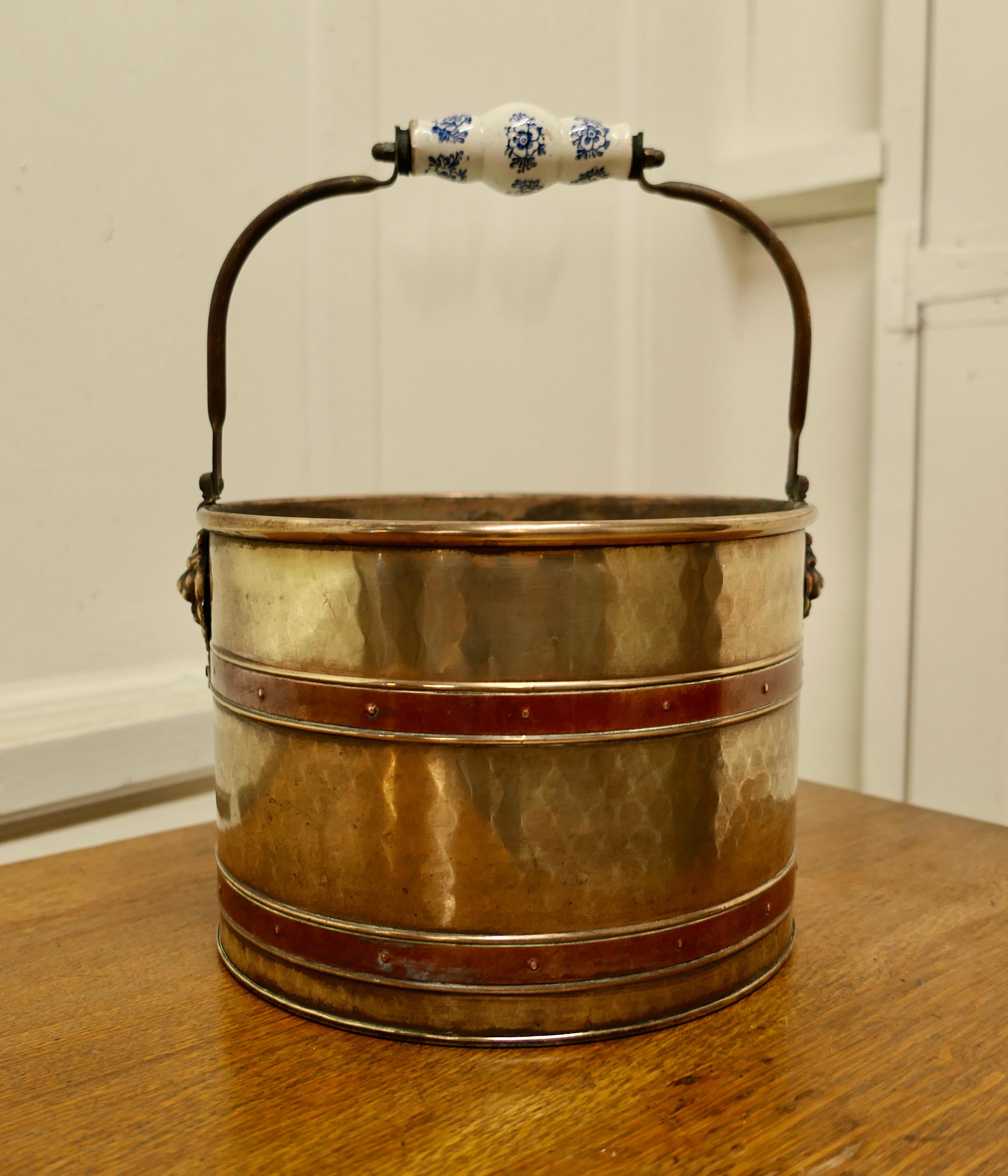 19th century copper and brass plant pot bucket or wine cooler

This is a lovely looking 19th Century planter it is made in brass with riveted copper bands and an Iron handle with a Delft style hand grip
The bucket has a rolled top edge and the