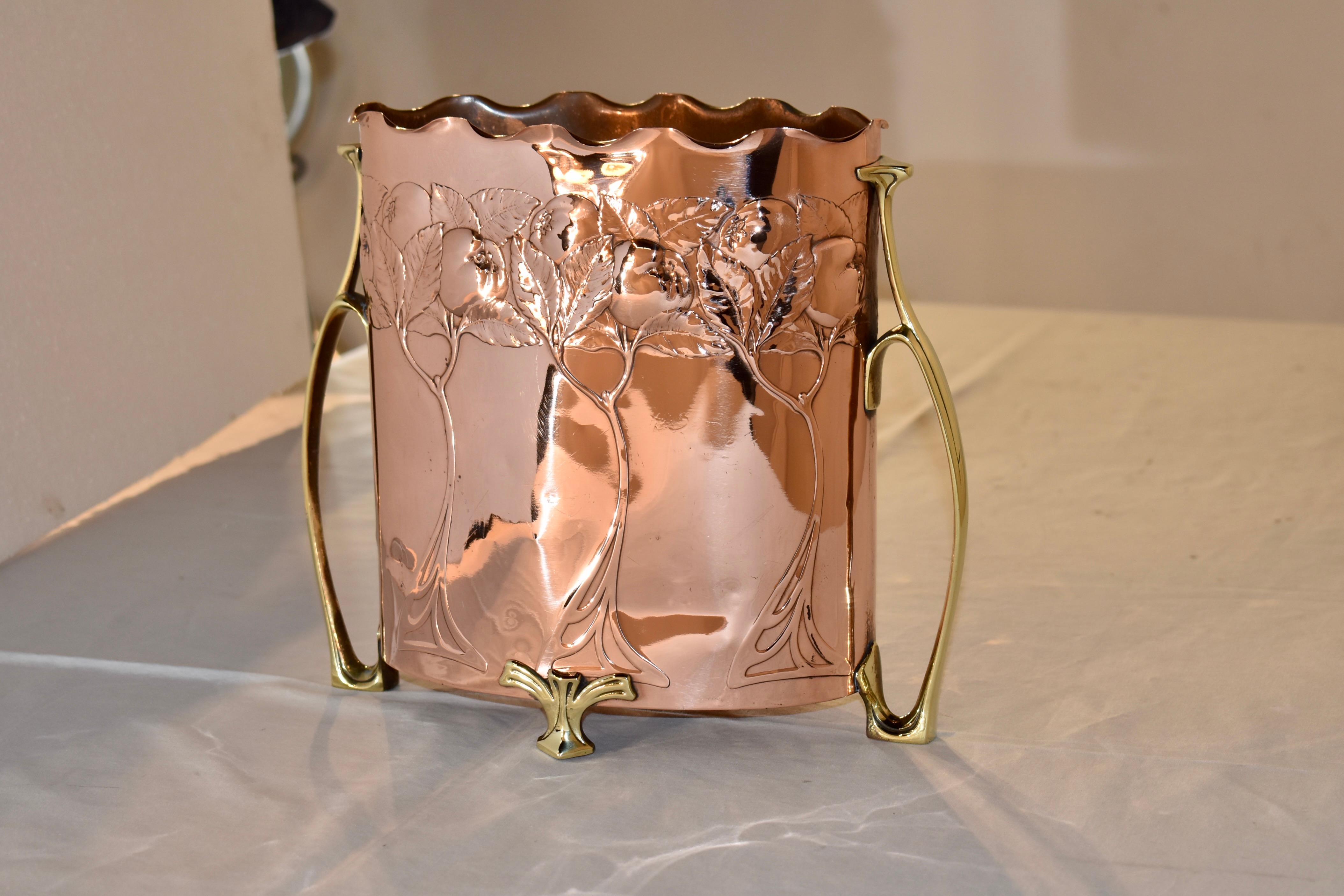 Late 19th century copper planter from France.  The planter is oval in shape, and is fluted at the top, and is hand embossed with trees, leaves and fruit.  The handles and feet are hand applied and are cast in brass in typical Art Nouveau style.  The