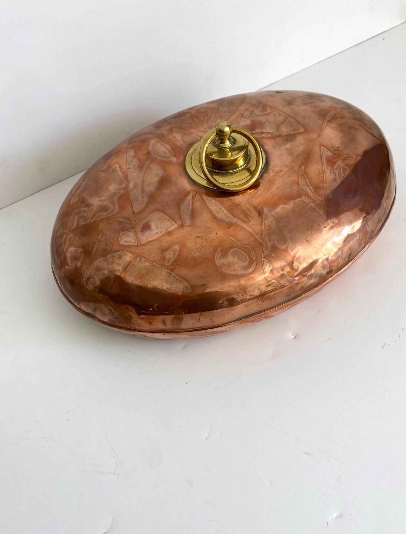19th-century copper bed warmer with a brass cap.