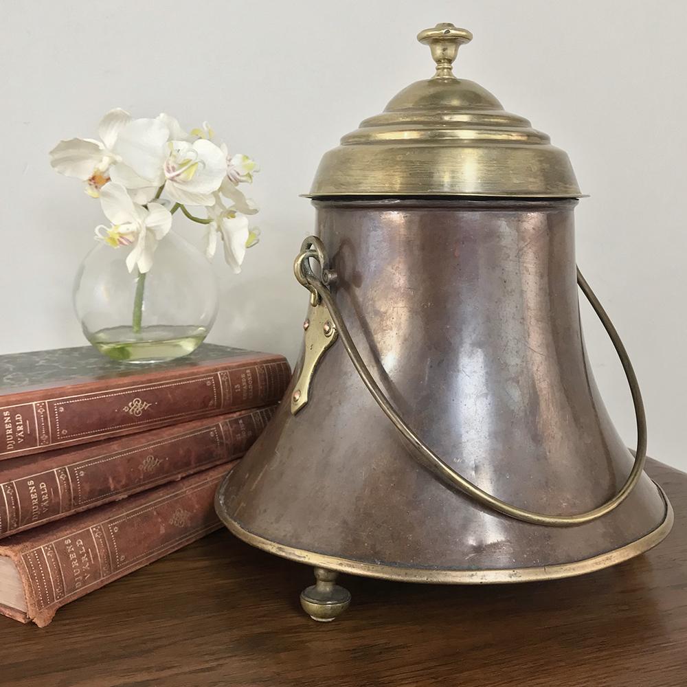 19th century copper and brass kindling pot is a charming reminder of a bygone era, and was carefully handcrafted from hand-formed copper and cast and formed brass in a footed design that prevented condensation. The flared bottom was an ingenious way