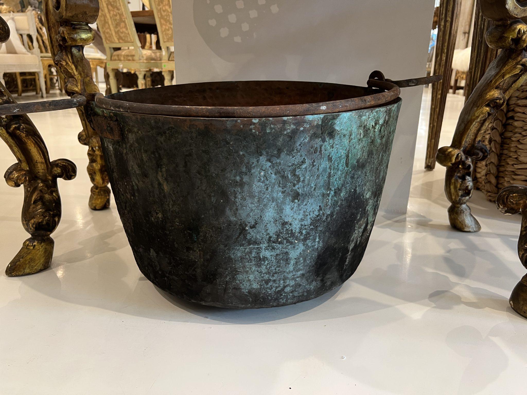 Large heavily patinated copper kettle with handle. Could be used as a vessel for a large flower arrangement or as a receptacle for wood next to the fireplace.