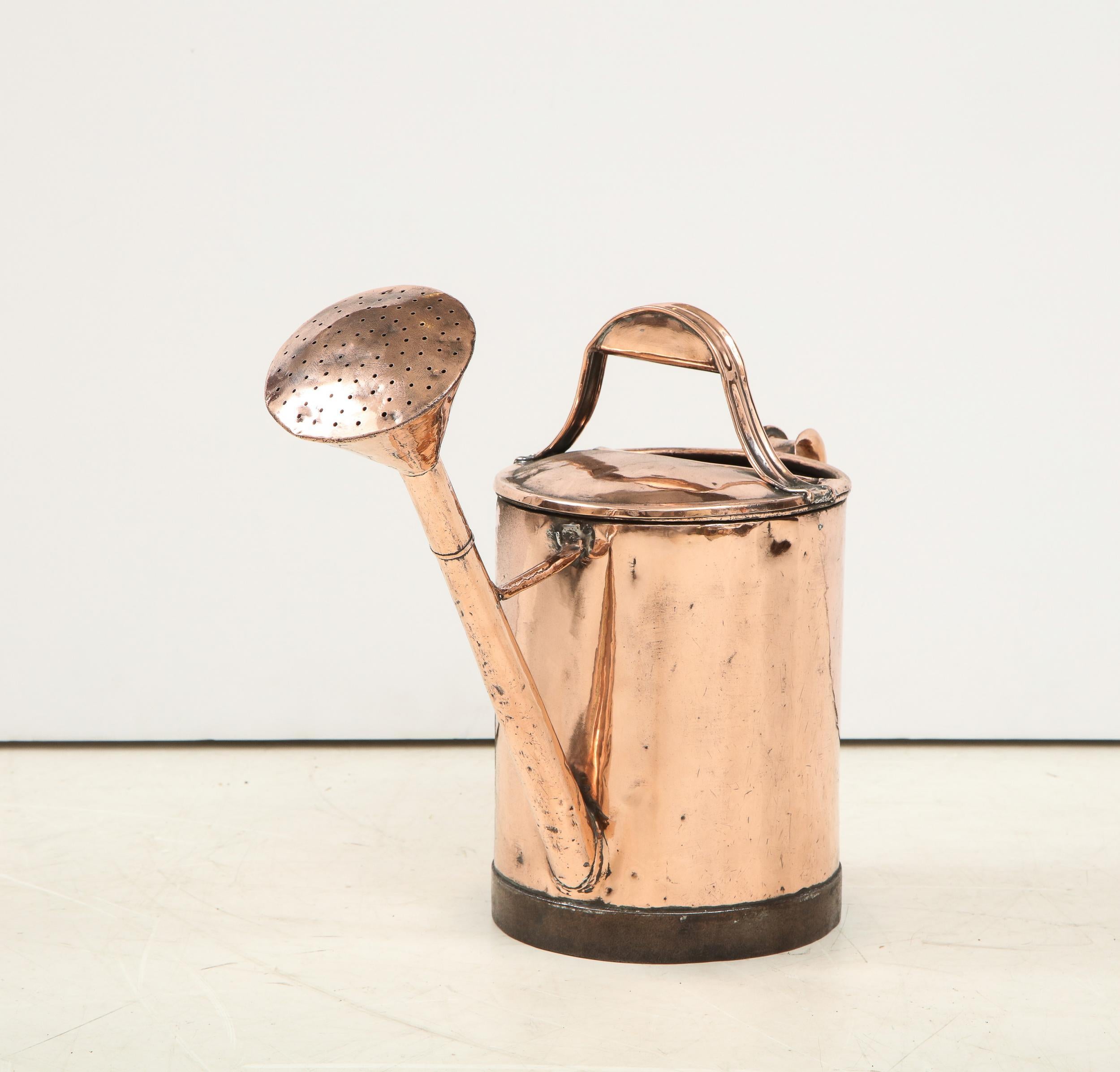 Good 19th century copper watering can of cylindrical form, having both a carrying and pouring handle, extended flower head and wrought iron reinforced base.