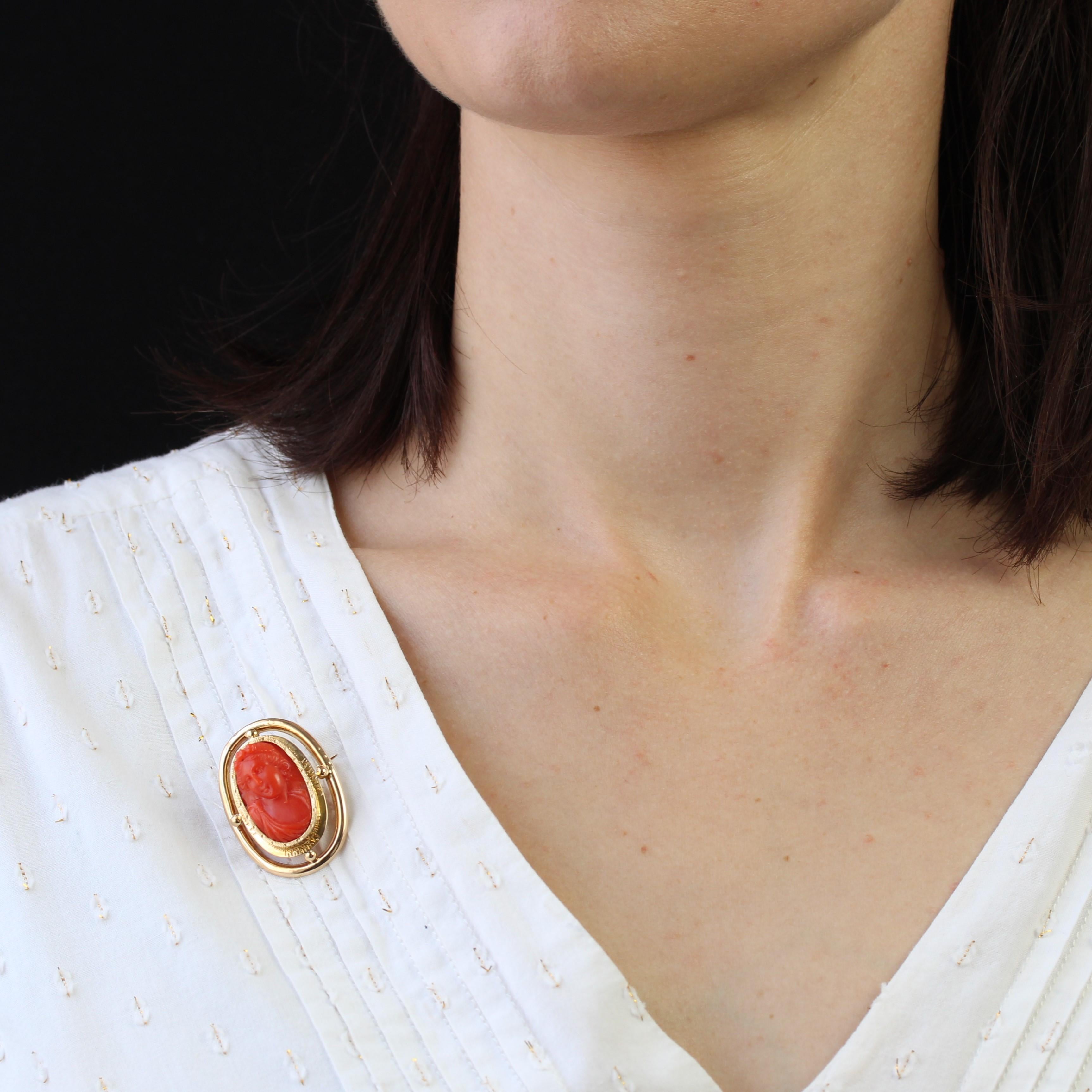Brooch in 18 karats yellow gold.
Elegant and sober, this antique cameo features an oval motif in smooth openwork gold, adorned at the 4 cardinal points with a small gold pearl. The cameo's surround is chased with geometric motifs. The coral depicts