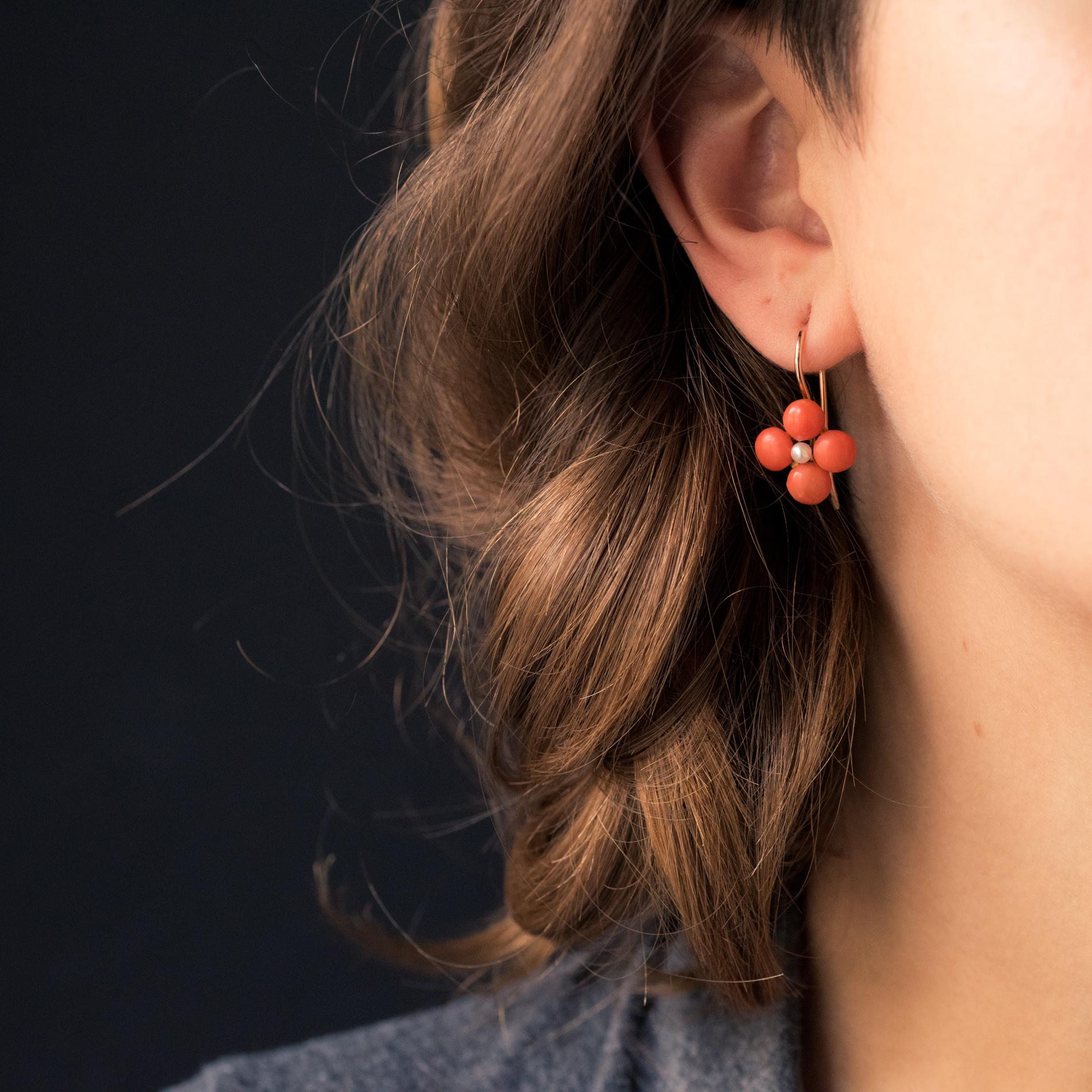 For pierced ears.
Earrings in 18 karat rose gold.
Bright and refined, each earring is composed of a clover pattern set with 4 coral cabochons centered with a natural pearl. The clasp is a gooseneck.
Height: 1.5 cm, width: 0.9 cm, thickness: 0.6