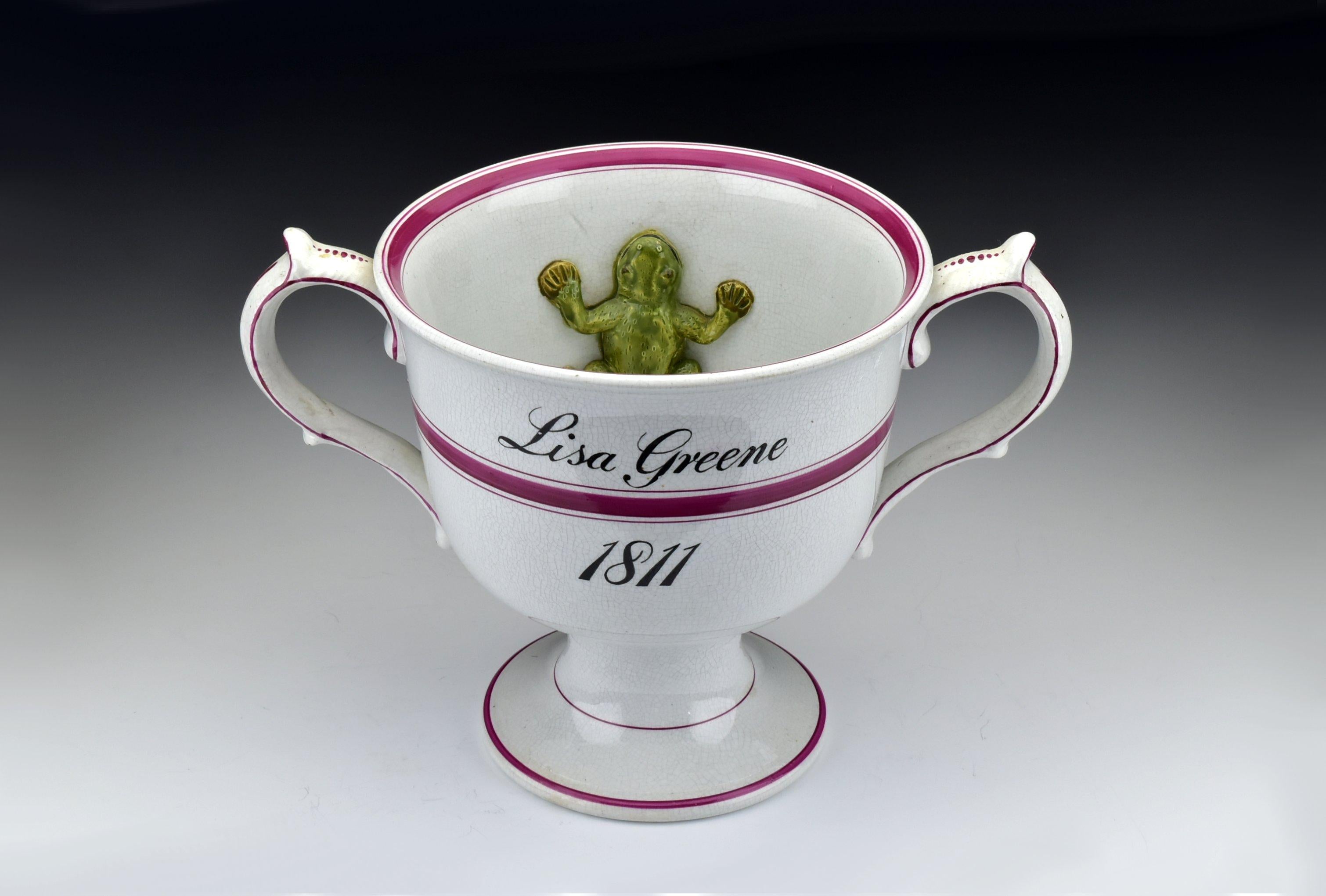 Description: English Staffordshire loving cup decorated with a figural frog on the inside and inscribed 