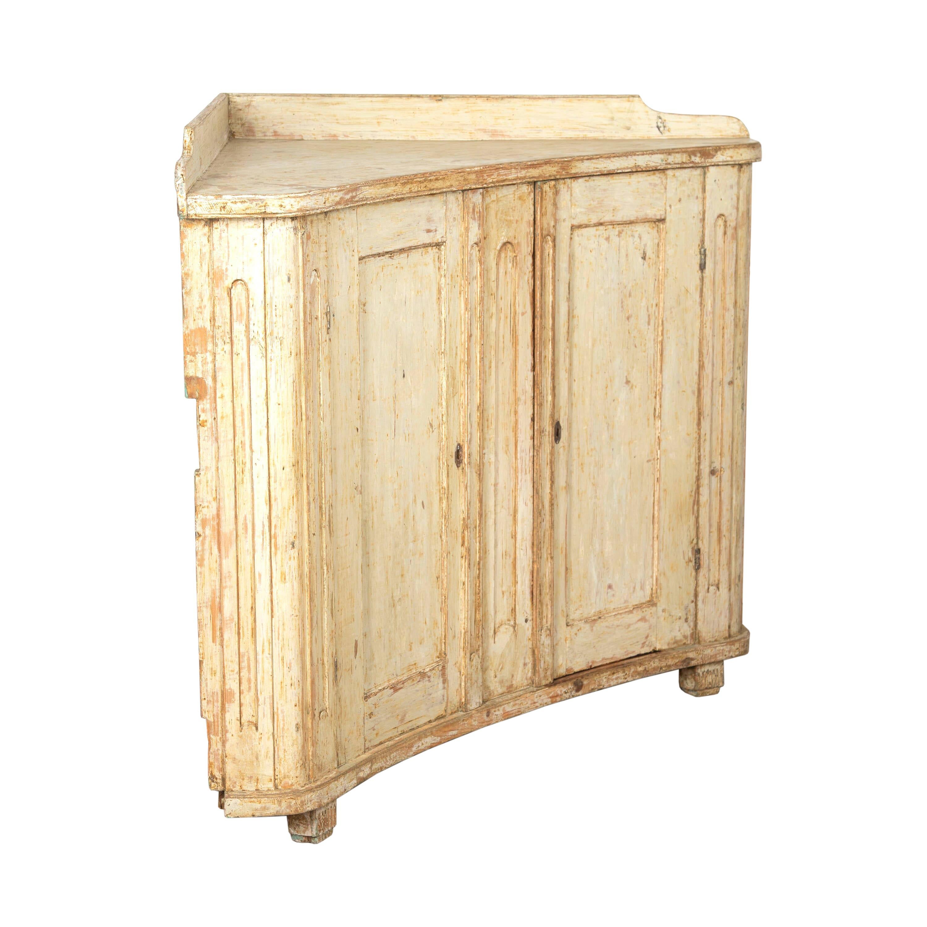 Gustavian low corner buffet from the North of Sweden.
This buffet features two large curved and paneled doors that open to useful storage. It has been later scraped to reveal its original paintwork which is clean and elegant cream.
It measures