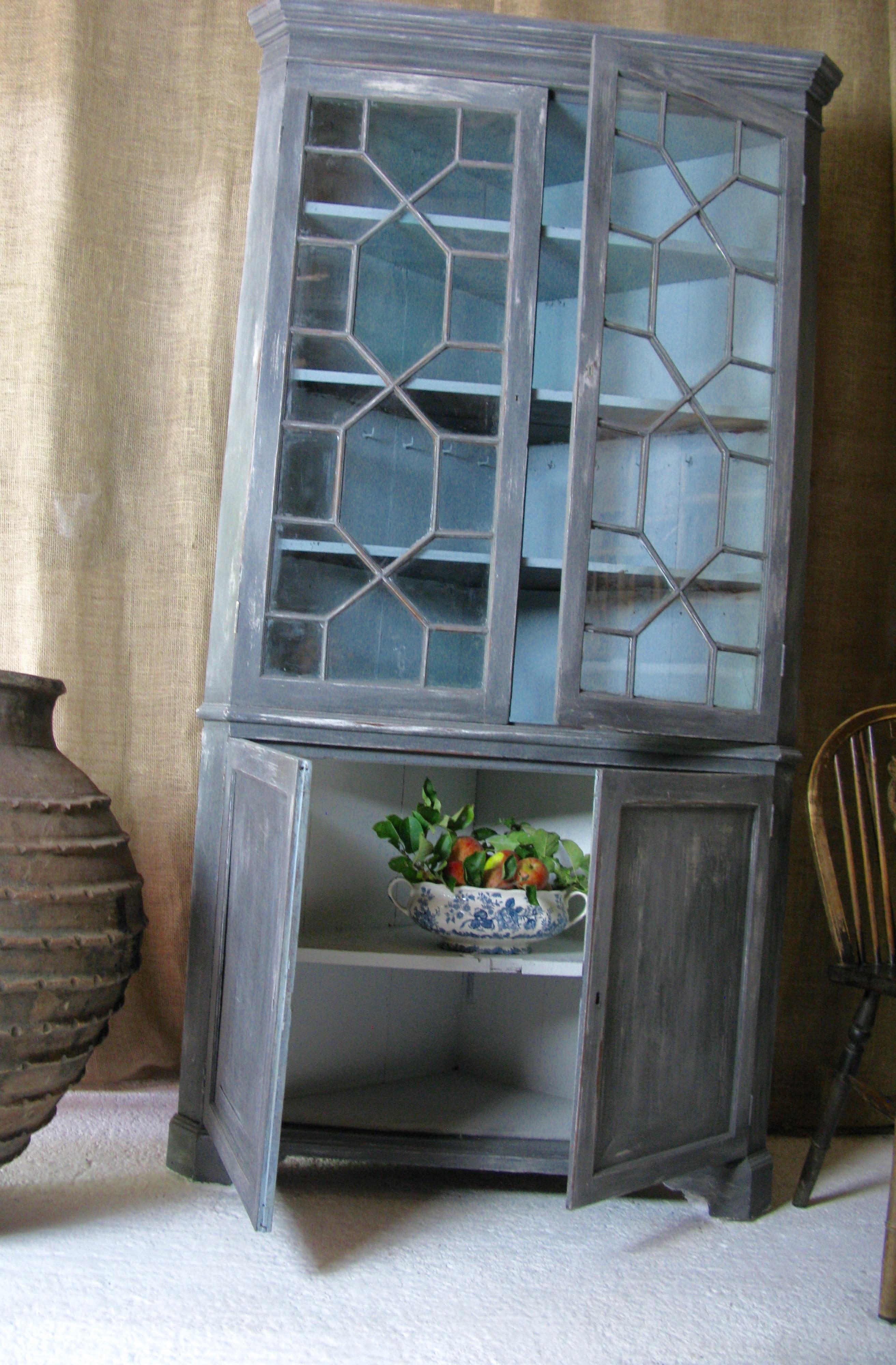 Lovely antique English desirable corner cabinet.

The antique cabinet has borders inside for plates.
Painted in an organic style

My choice; 
This is a lovely cupboard for a kitchen or lovely pantry for jams, chutneys seasonal vegetables and
