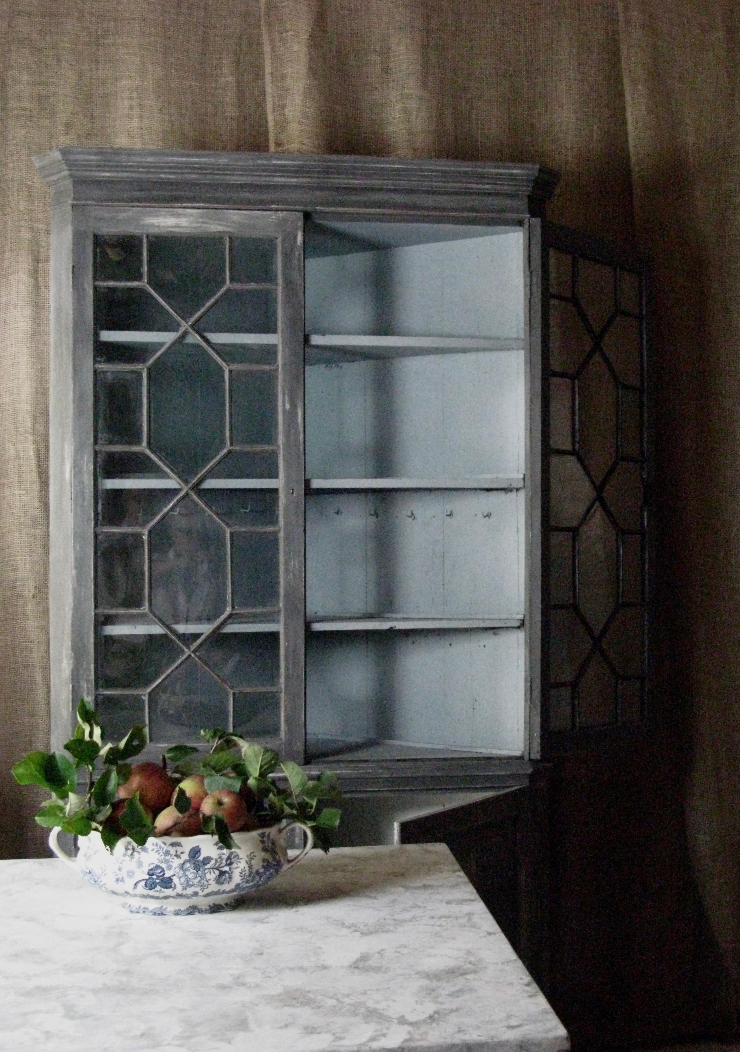 Lovely antique English desirable corner cabinet.

The antique cabinet has borders inside for plates.
Painted in an organic style

My choice; 
This is a lovely cupboard for a kitchen or lovely pantry for jams, chutneys seasonal vegetables and