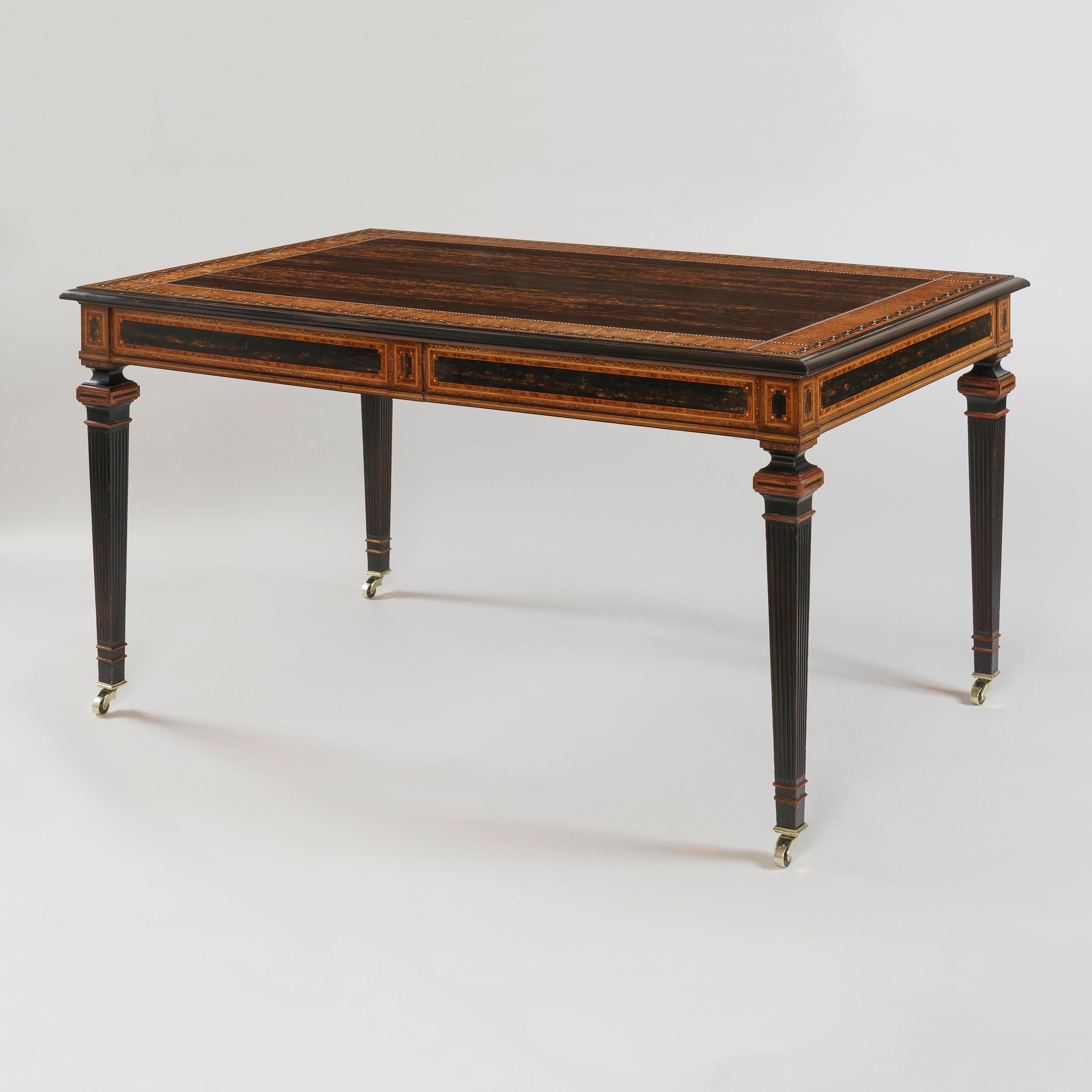 A magnificent library table 
Attributed to Jackson & Graham

Of free standing rectangular form, constructed in coromandel, with inlays in thuya, ebony, boxwood, and honeysuckle; the fluted legs rising from square brass castor-shod feet; the