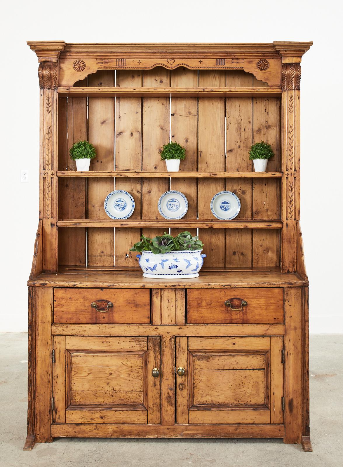 Two-part weathered 19th century country English welsh dresser cabinet or sideboard buffet crafted from pine. Beautifully aged with a desirable patina on the pine finish. The sideboard dresser has two large storage drawers with two doors below