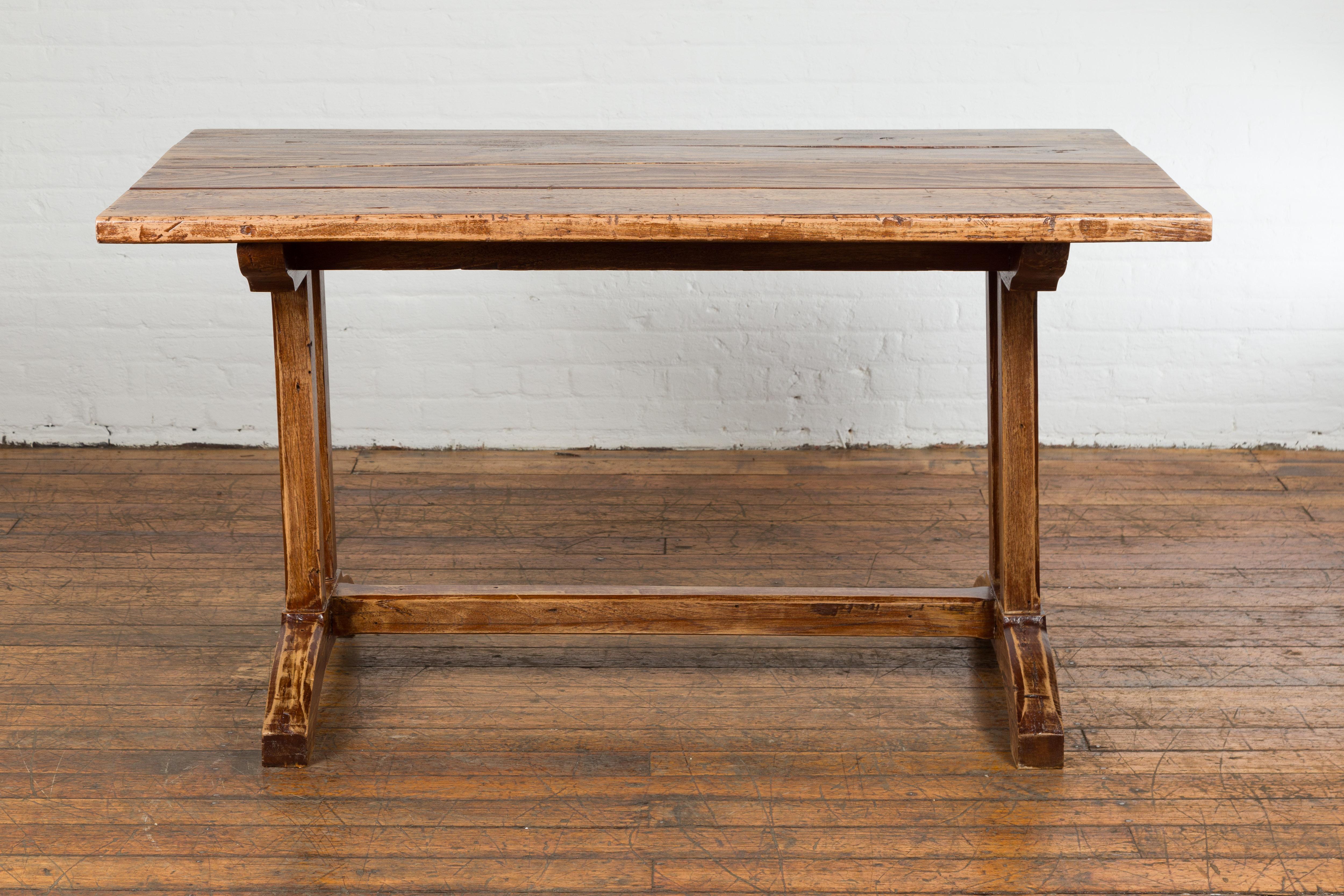 Indonesian 19th Century Country Farmhouse Table with Trestle Base and Distressed Finish For Sale