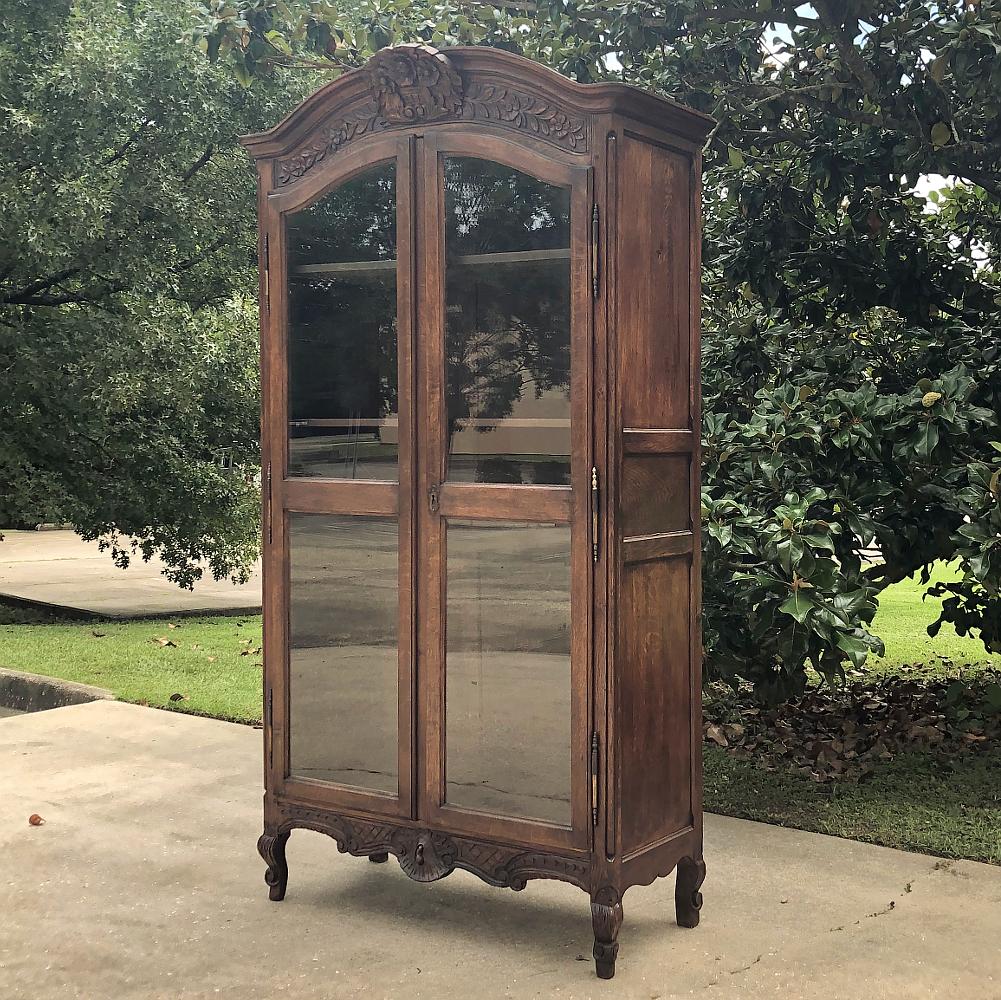 19th century Country French bookcase is a splendid way to display any collection, keepsakes or memorabilia! Hand-crafted from solid oak and carved with a natural charm that is a common trait of rural French furnishings, it features a broad arched