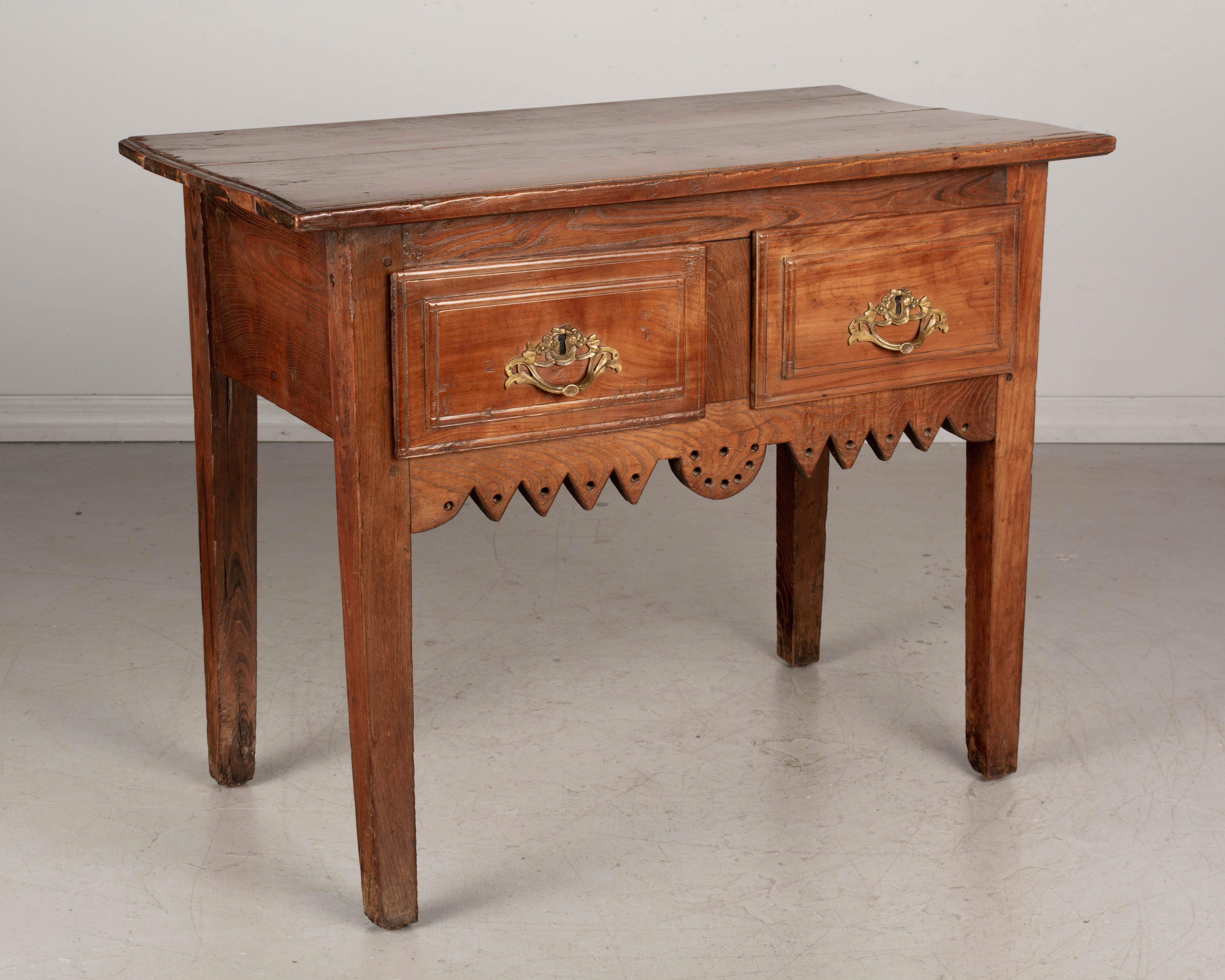 An early 19th century Country French console table from Central France. The face of the drawers and the top are made of solid cherry wood and the case is made of chestnut. Two deep drawers with bronze pulls that are old, but not original to this